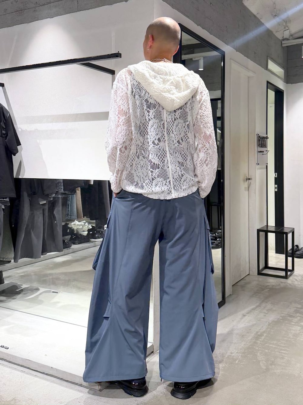 ホワイト系のタンクトップ、ブルー系のカーゴパンツ、ブラック系のサンダルを着用したメンズの夏コーディネートの3枚目の写真