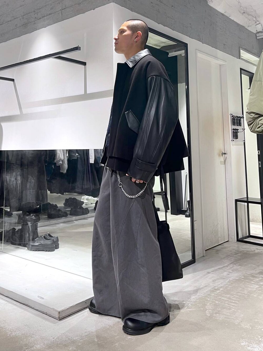 ブラック系のブルゾン、ブラック系のトートバッグ、グレー系のスラックスを着用したメンズの秋コーディネートの2枚目の写真