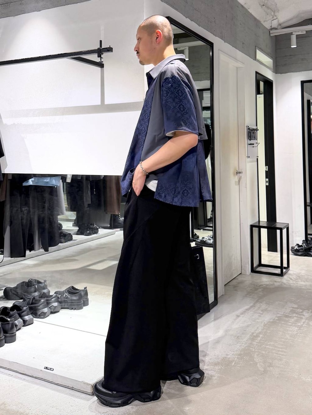 ブラック系のスニーカー、ホワイト系のTシャツ/カットソー、ブラック系のスラックスを着用したメンズの夏コーディネートの2枚目の写真