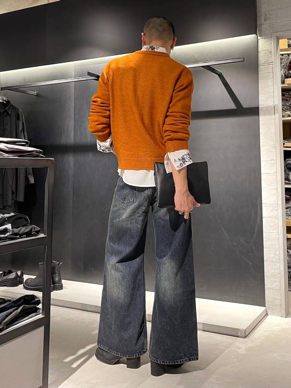 ブラック系のトートバッグ、ブルー系のデニムパンツ、ホワイト系のシャツ/ブラウスを着用したメンズの秋コーディネートの4枚目の写真