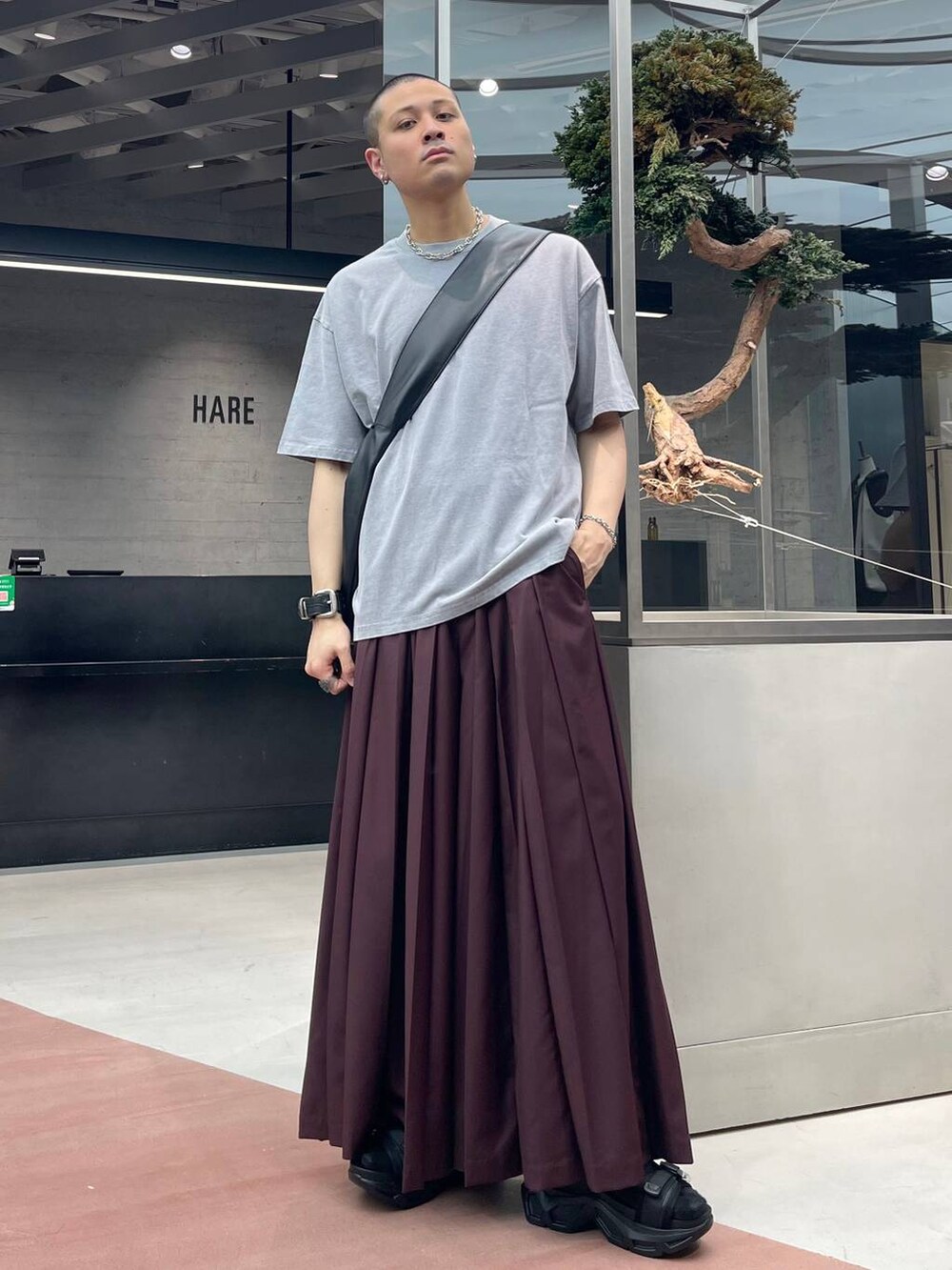 レッド系のその他パンツ、ブラック系のショルダーバッグ、ブラック系のサンダルを着用したメンズの夏コーディネートの2枚目の写真