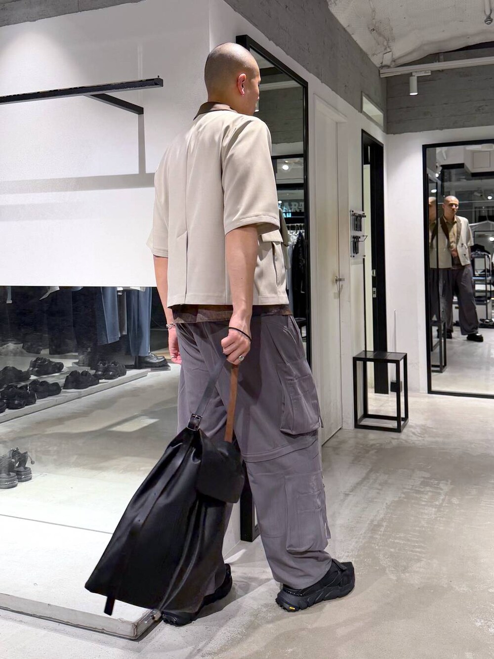 ブラック系のサンダル、グレー系のカーゴパンツ、ブラック系のトートバッグを着用したメンズの春コーディネートの4枚目の写真