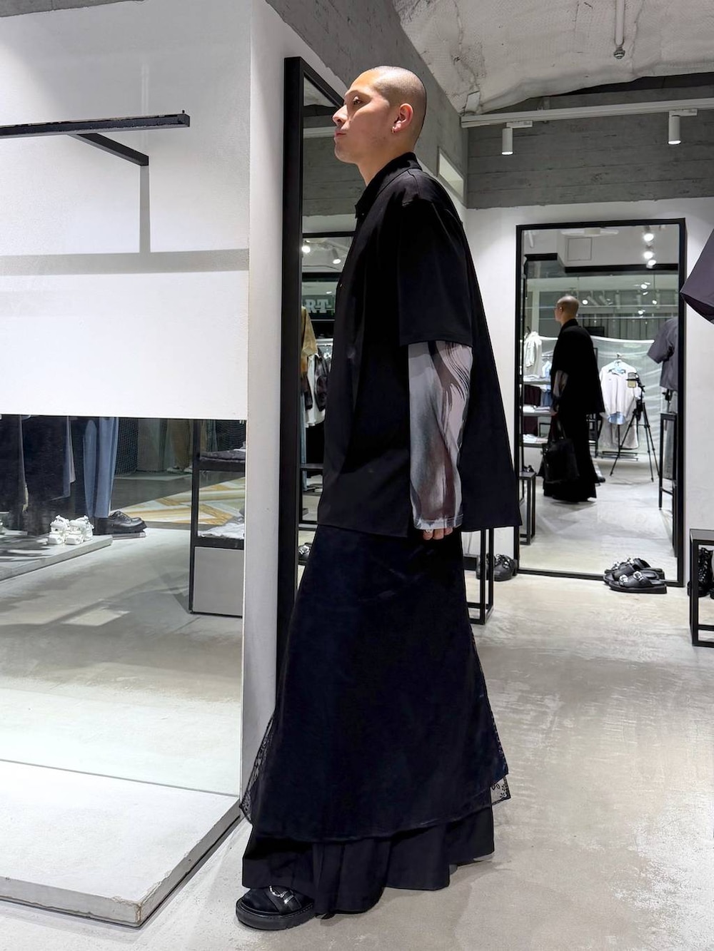 ブラック系のサンダル、ブラック系のトートバッグ、ブラック系のスラックスを着用したメンズの春コーディネートの3枚目の写真