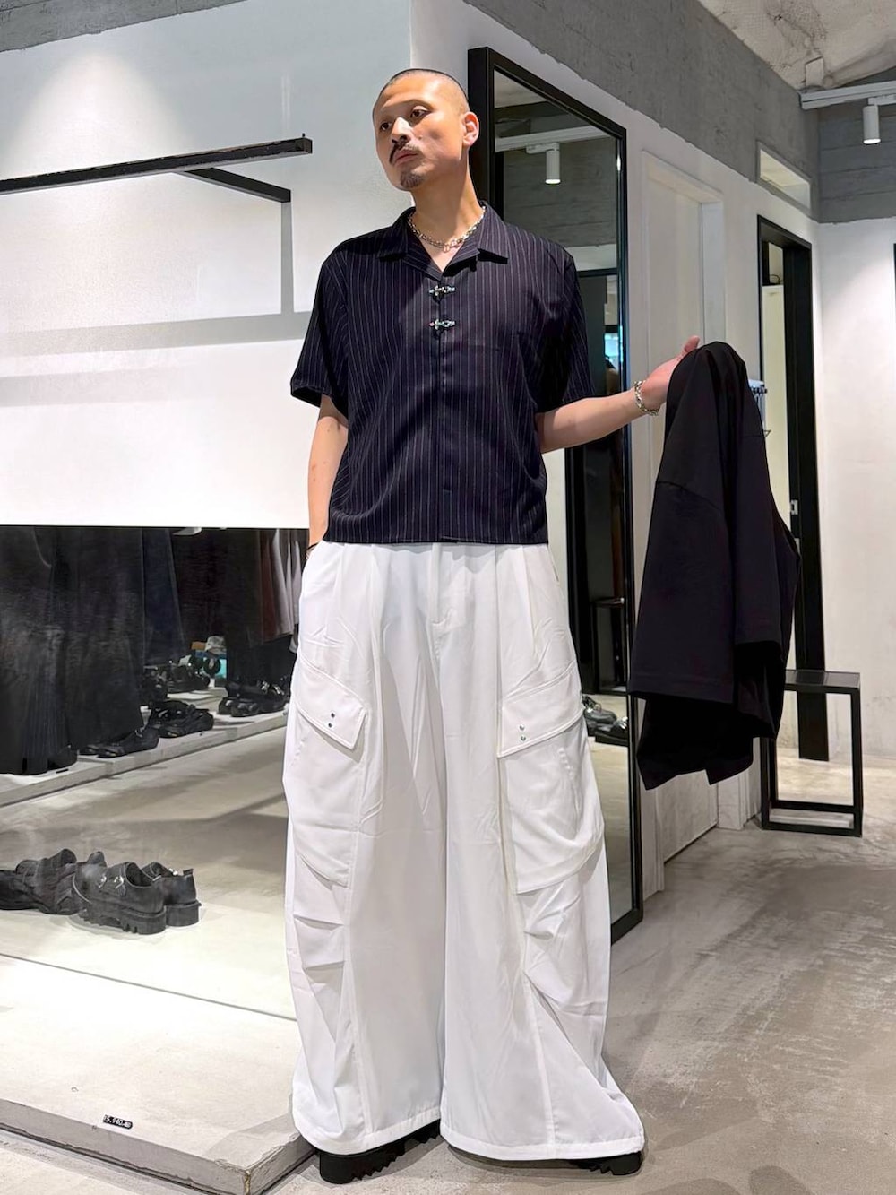 ブラック系のサンダル、ブラック系のトートバッグ、グレー系のブレスレットを着用したメンズの夏コーディネートの5枚目の写真