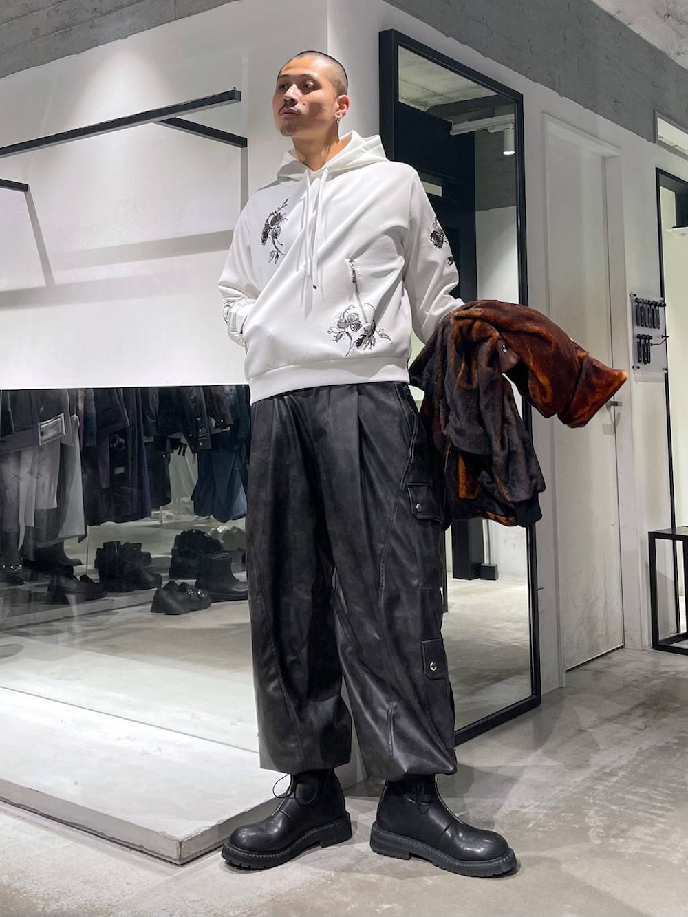 オレンジ系のブルゾン、グレー系のカーゴパンツ、ブラック系のブーツを着用したメンズの秋コーディネートの5枚目の写真