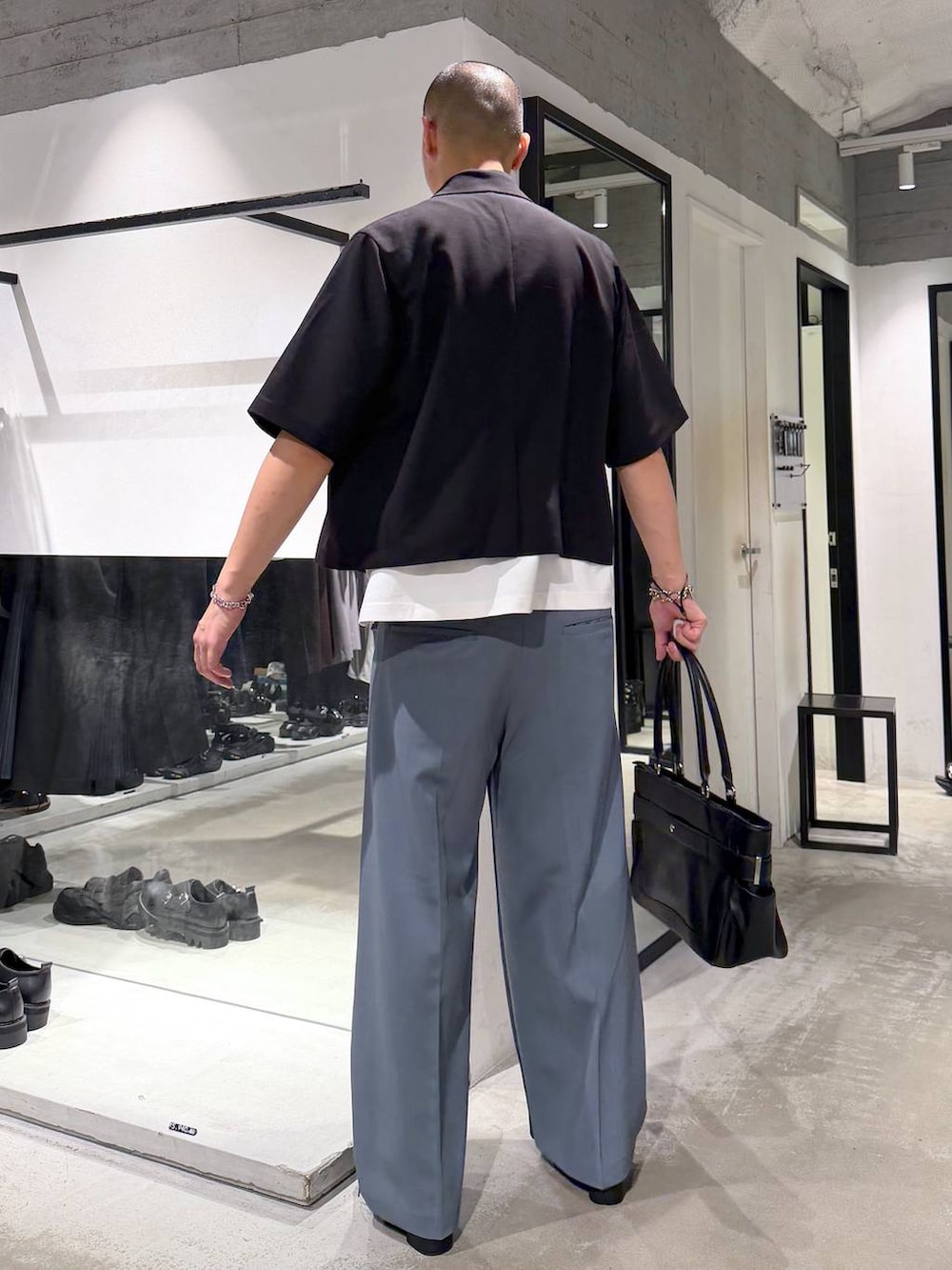 ブラック系のサンダル、ブルー系のスラックス、ホワイト系のTシャツ/カットソーを着用したメンズの夏コーディネートの3枚目の写真