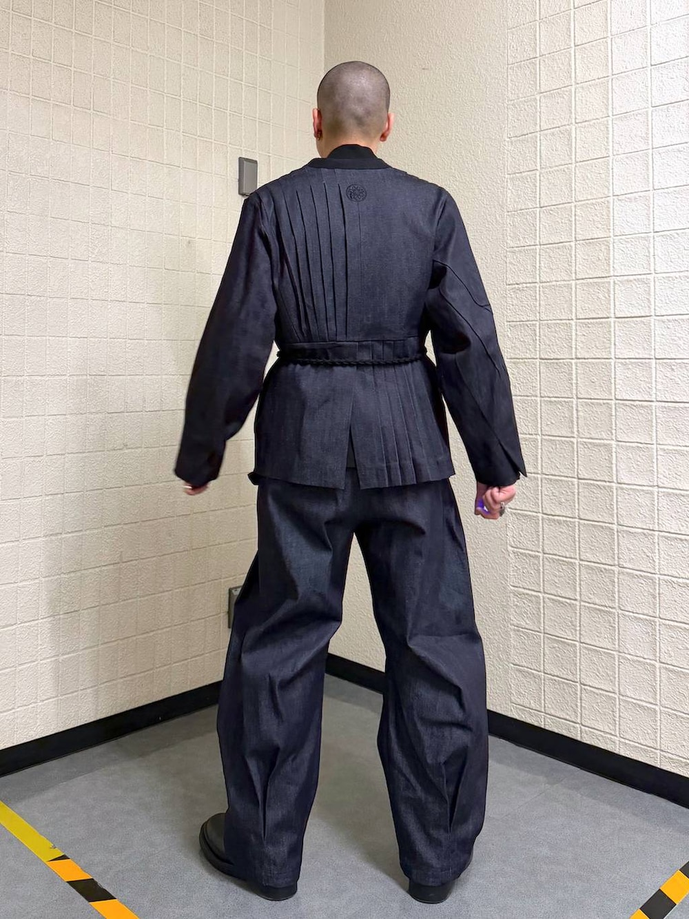 ブルー系のノーカラージャケット、ブルー系のデニムパンツを着用したメンズの春コーディネートの4枚目の写真