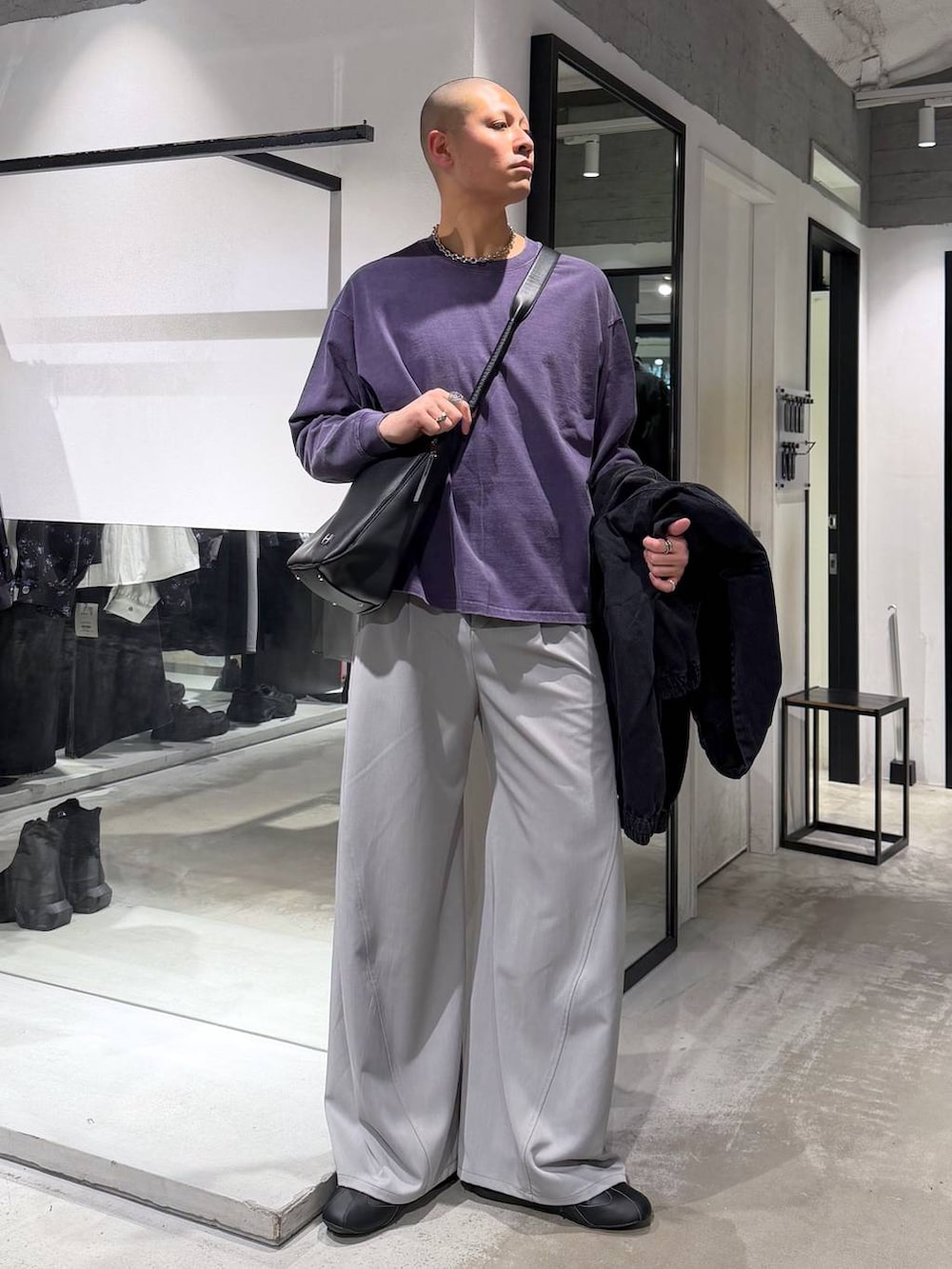 ブラック系のブルゾン、グレー系のスラックス、ブラック系のショルダーバッグを着用したメンズの春コーディネートの6枚目の写真