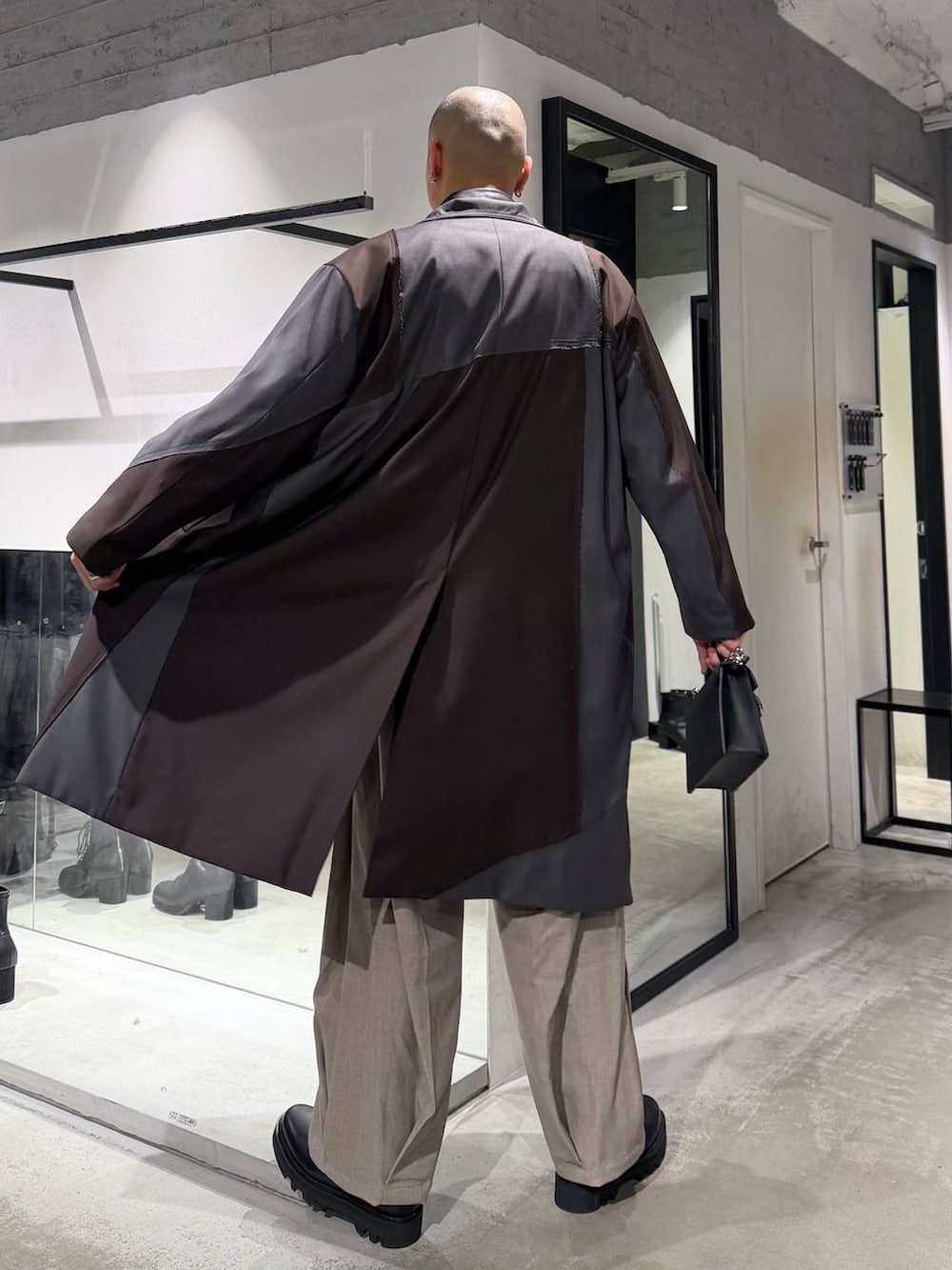 ブラック系のドレスシューズ、ブラック系のハンドバッグ、ブラック系のカーディガン/ボレロを着用したメンズの冬コーディネートの3枚目の写真