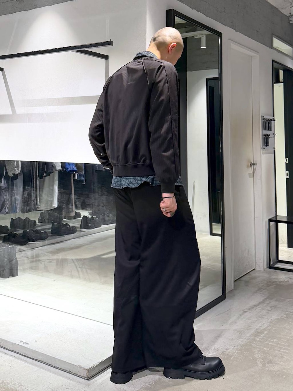 ブラック系のドレスシューズ、ブラック系のスラックス、ブラウン系のその他トップスを着用したメンズの春コーディネートの4枚目の写真