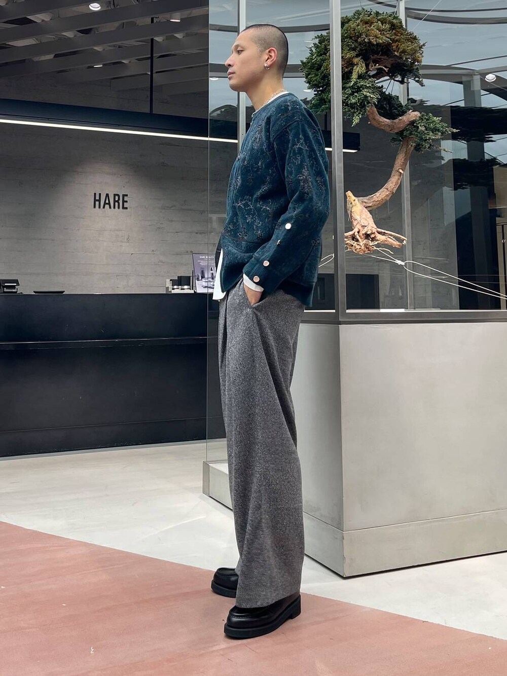 グリーン系のカーディガン/ボレロ、ブラック系のローファー、ブラック系のスラックスを着用したメンズの秋コーディネートの2枚目の写真