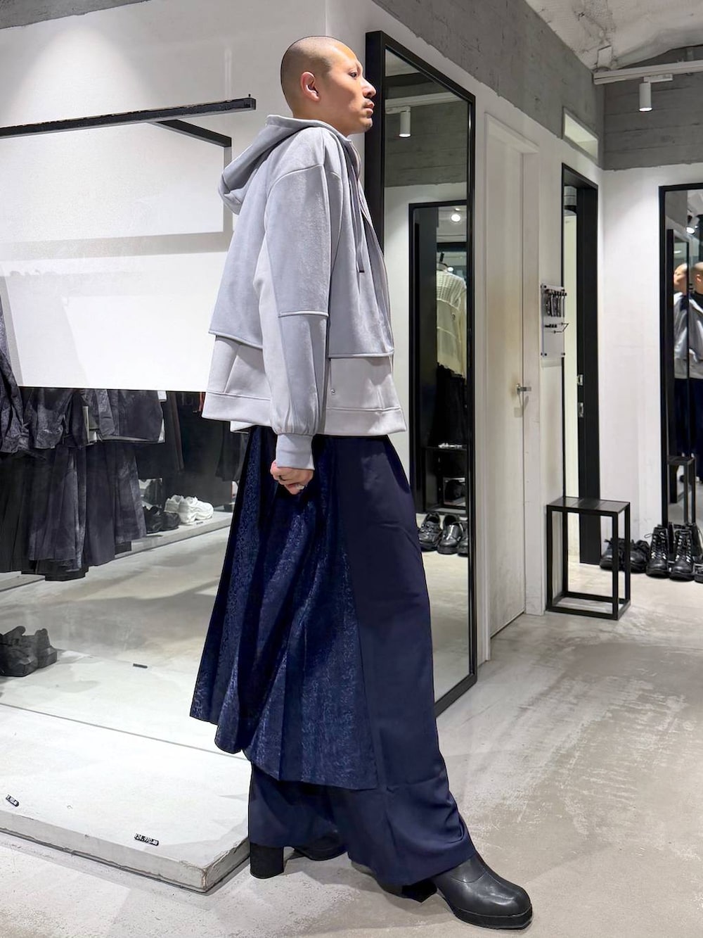グレー系のニット/セーター、ブラック系のブーツ、ブルー系のその他パンツを着用したメンズの秋コーディネートの4枚目の写真