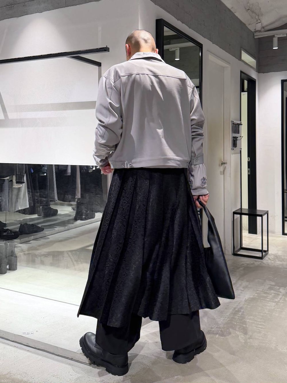 ブラック系のトートバッグ、グレー系のポロシャツ、ブラック系のその他パンツを着用したメンズの春コーディネートの4枚目の写真