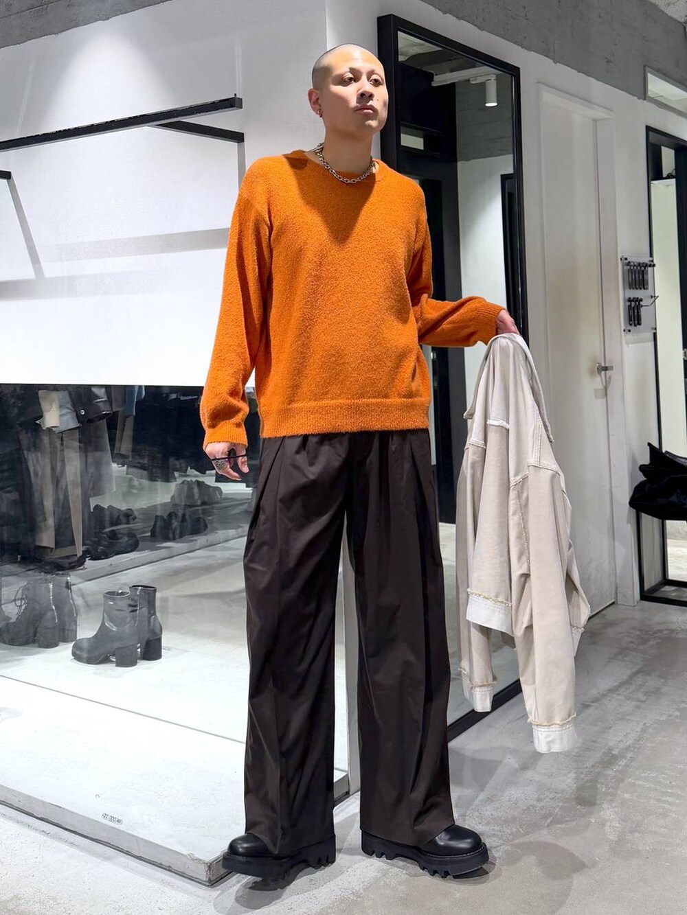 ブラック系のドレスシューズ、ブラック系のトートバッグ、オレンジ系のニット/セーターを着用したメンズの冬コーディネートの5枚目の写真