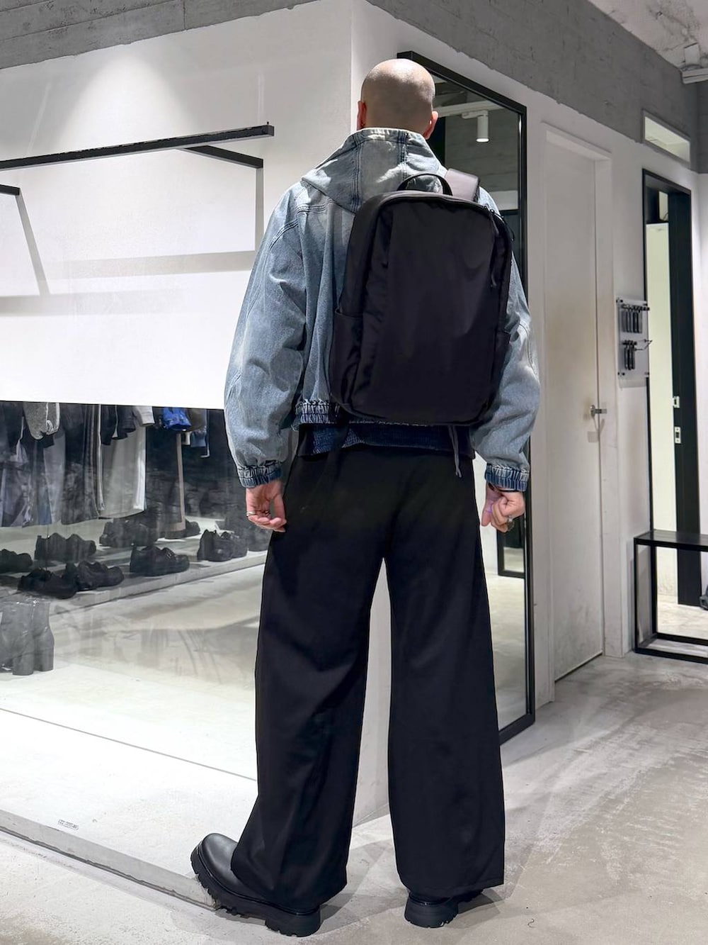 ブルー系のブルゾン、ブラック系のドレスシューズ、ブラック系のバックパック/リュックを着用したメンズの春コーディネートの4枚目の写真