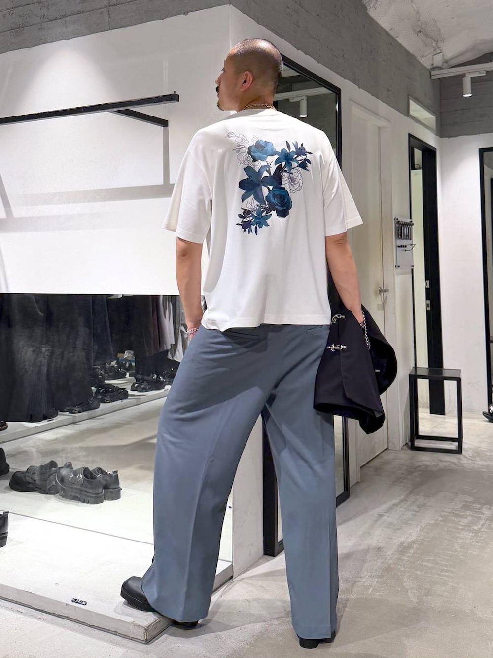ブラック系のサンダル、ブルー系のスラックス、ホワイト系のTシャツ/カットソーを着用したメンズの夏コーディネートの6枚目の写真