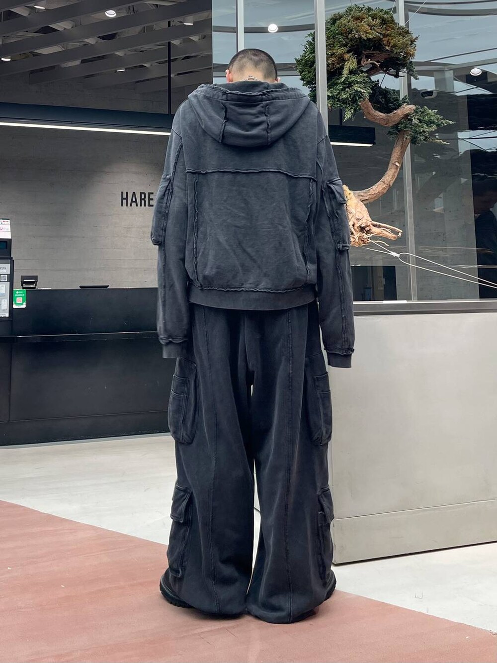 ブラック系のスウェットパンツ、ブラック系のパーカー、ブラック系のブーツを着用したメンズの秋コーディネートの3枚目の写真