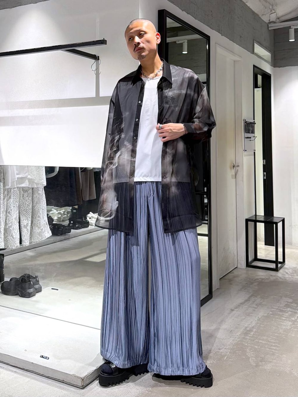 ブラック系のサンダル、ブルー系のスラックス、ホワイト系のTシャツ/カットソーを着用したメンズの夏コーディネートの2枚目の写真