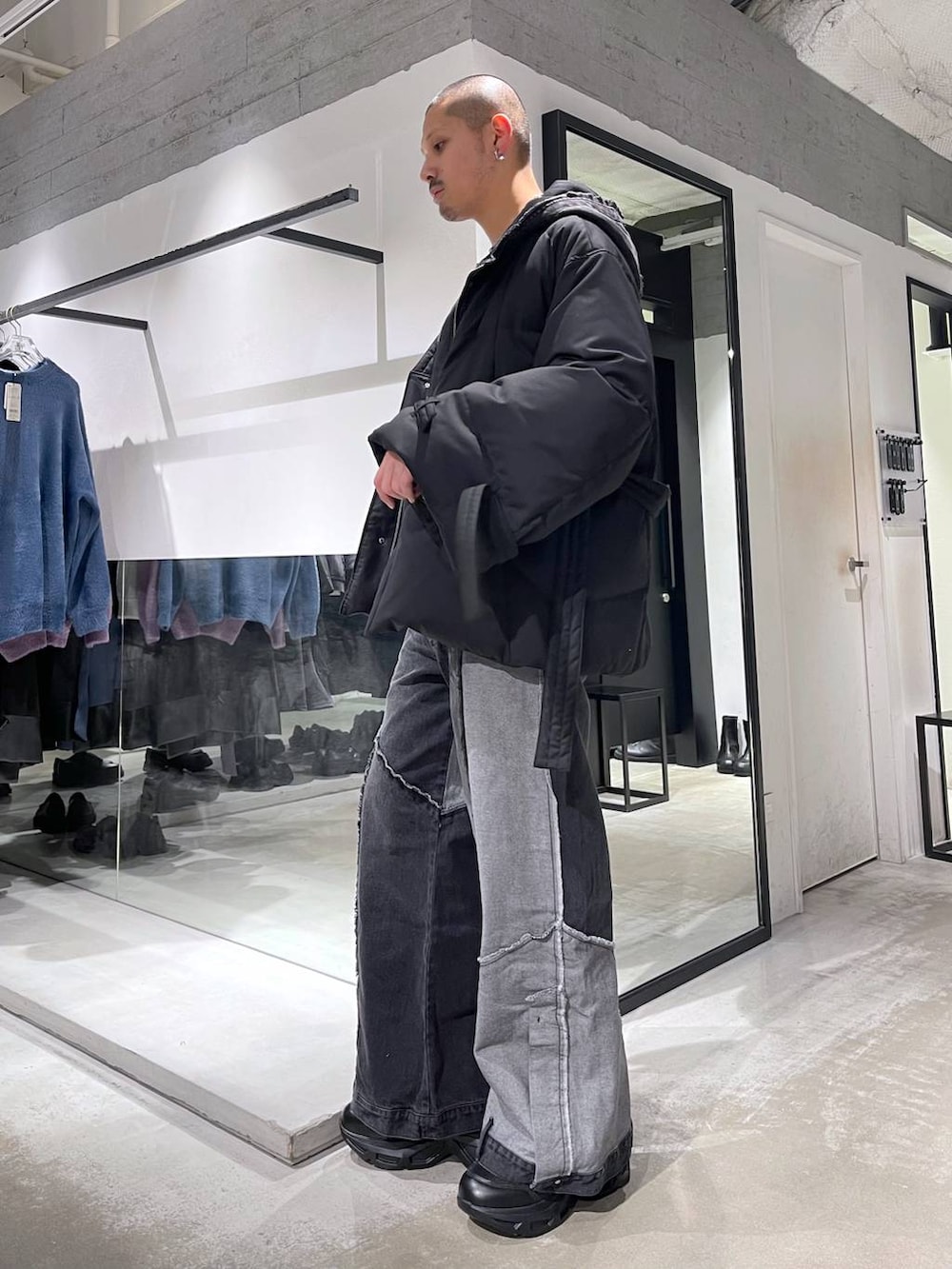 ブラック系のスニーカー、ブラック系のパーカー、ブラック系のデニムパンツを着用したメンズの冬コーディネートの2枚目の写真