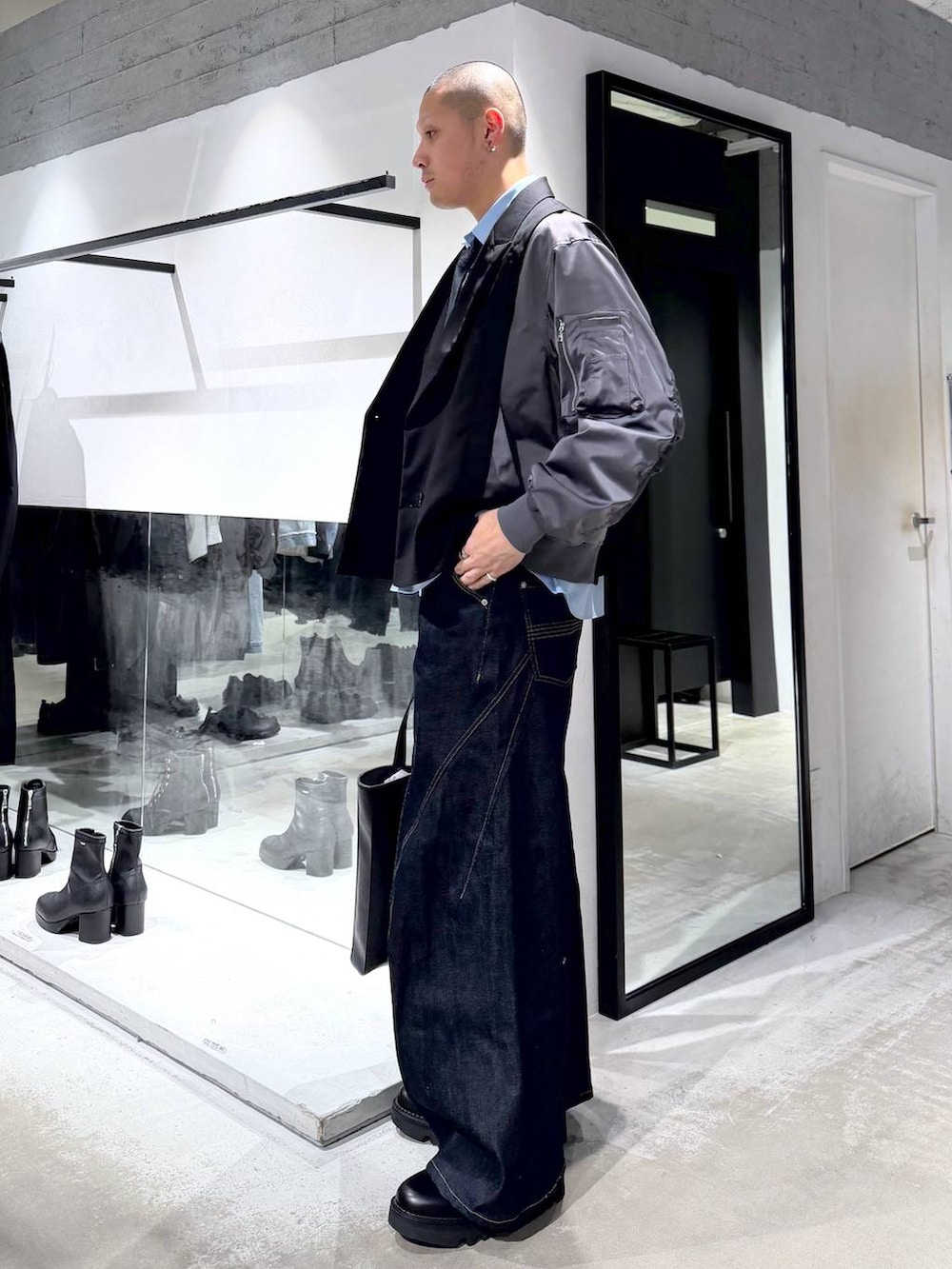 ブルー系のネクタイ、ブラック系のドレスシューズ、ブラック系のトートバッグを着用したメンズの冬コーディネートの2枚目の写真