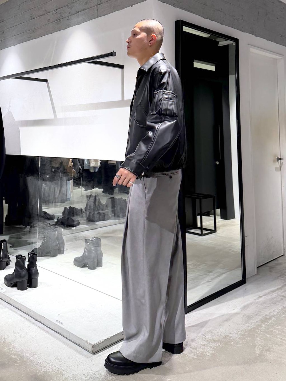 ブラック系のブルゾン、ブラック系のドレスシューズ、ブラック系のハンドバッグを着用したメンズの冬コーディネートの2枚目の写真