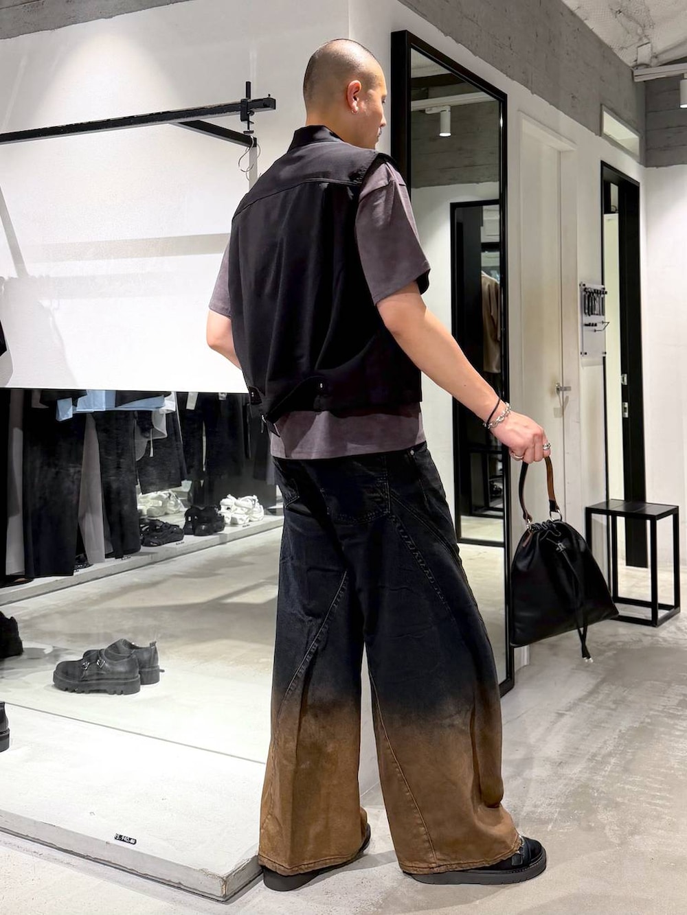 オレンジ系のデニムパンツ、ブラック系のサンダル、ブラック系のショルダーバッグを着用したメンズの夏コーディネートの4枚目の写真