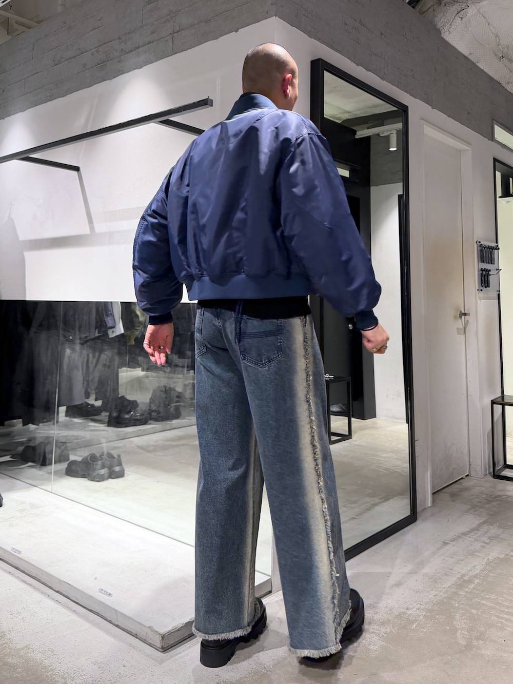 ブラック系のニット/セーター、ブラック系のドレスシューズ、ブルー系のMA-1を着用したメンズの冬コーディネートの3枚目の写真