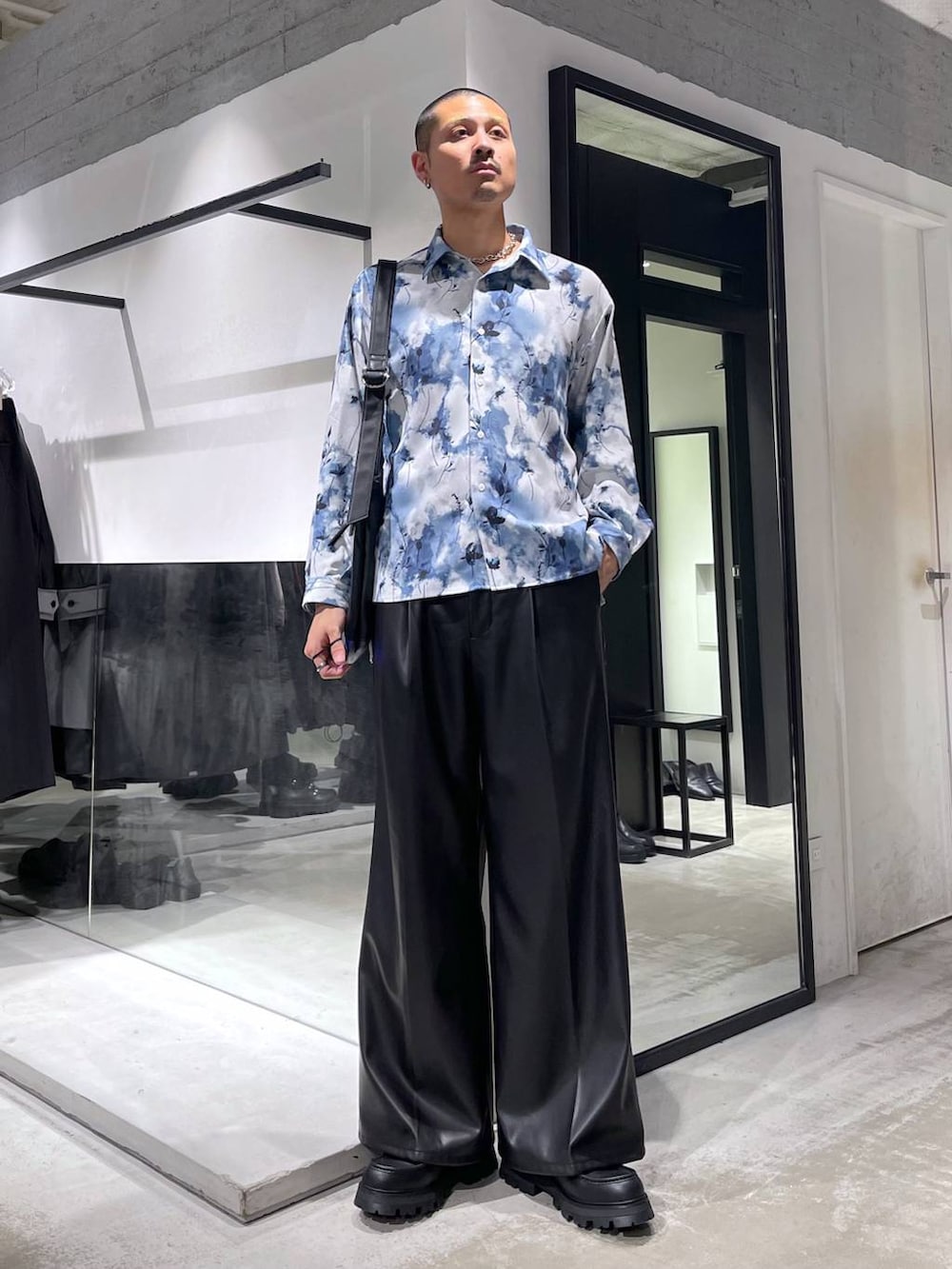 ブラック系のスラックス、ブラック系のドレスシューズ、ブラック系のショルダーバッグを着用したメンズの冬コーディネートの6枚目の写真