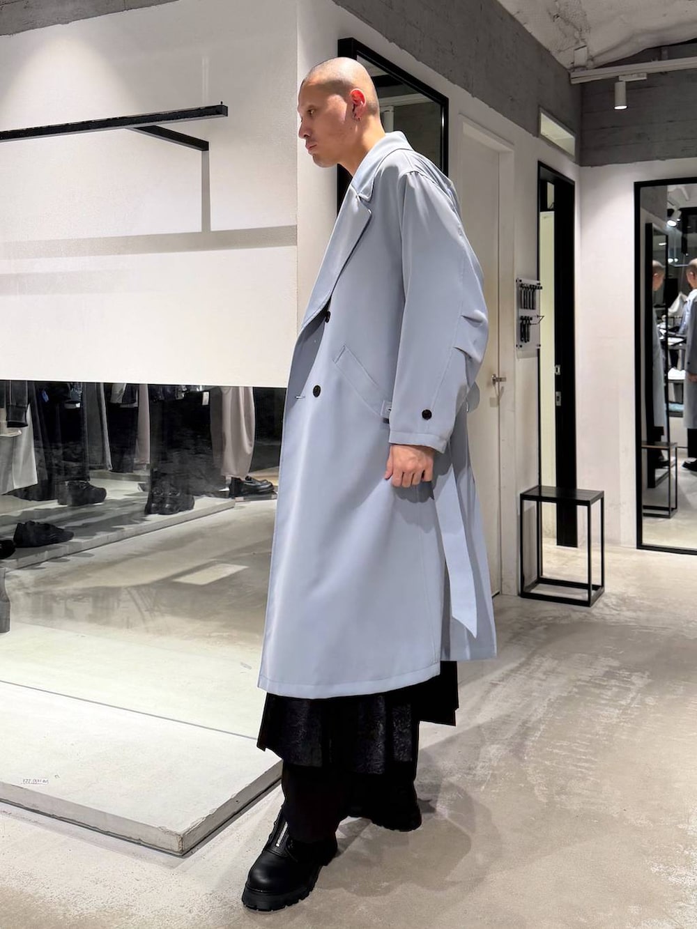 ブラック系のその他パンツ、ブラック系のドレスシューズ、グリーン系のトレンチコートを着用したメンズの春コーディネートの2枚目の写真