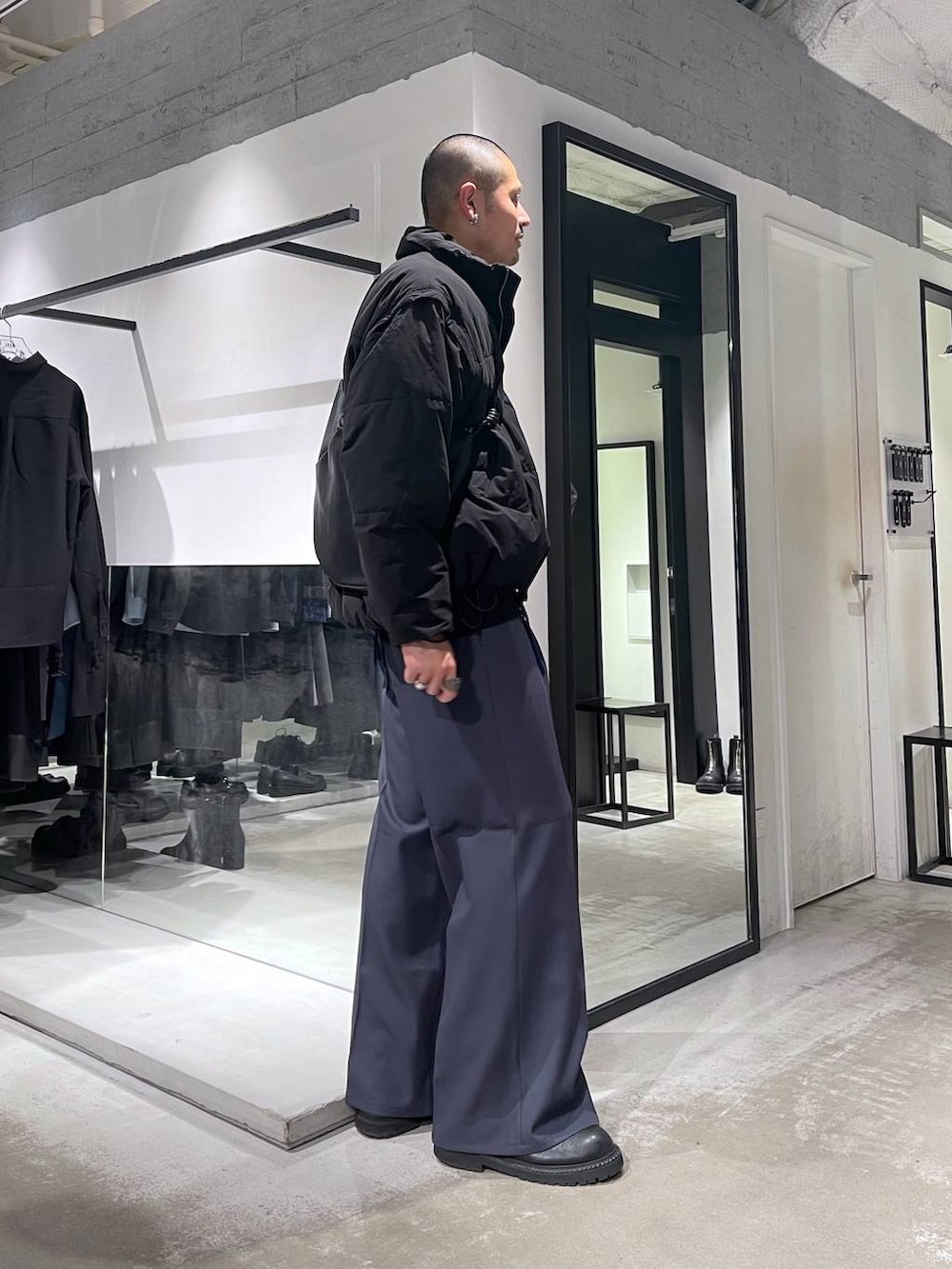 ブラック系のダウンジャケット/コート、ブラック系のブーツ、ブラック系のショルダーバッグを着用したメンズの冬コーディネートの4枚目の写真