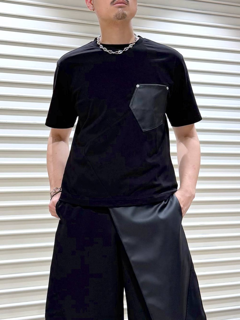 ブラック系のスラックス、ブラック系のTシャツ/カットソー、ブラック系のスニーカーを着用したメンズの夏コーディネートの5枚目の写真