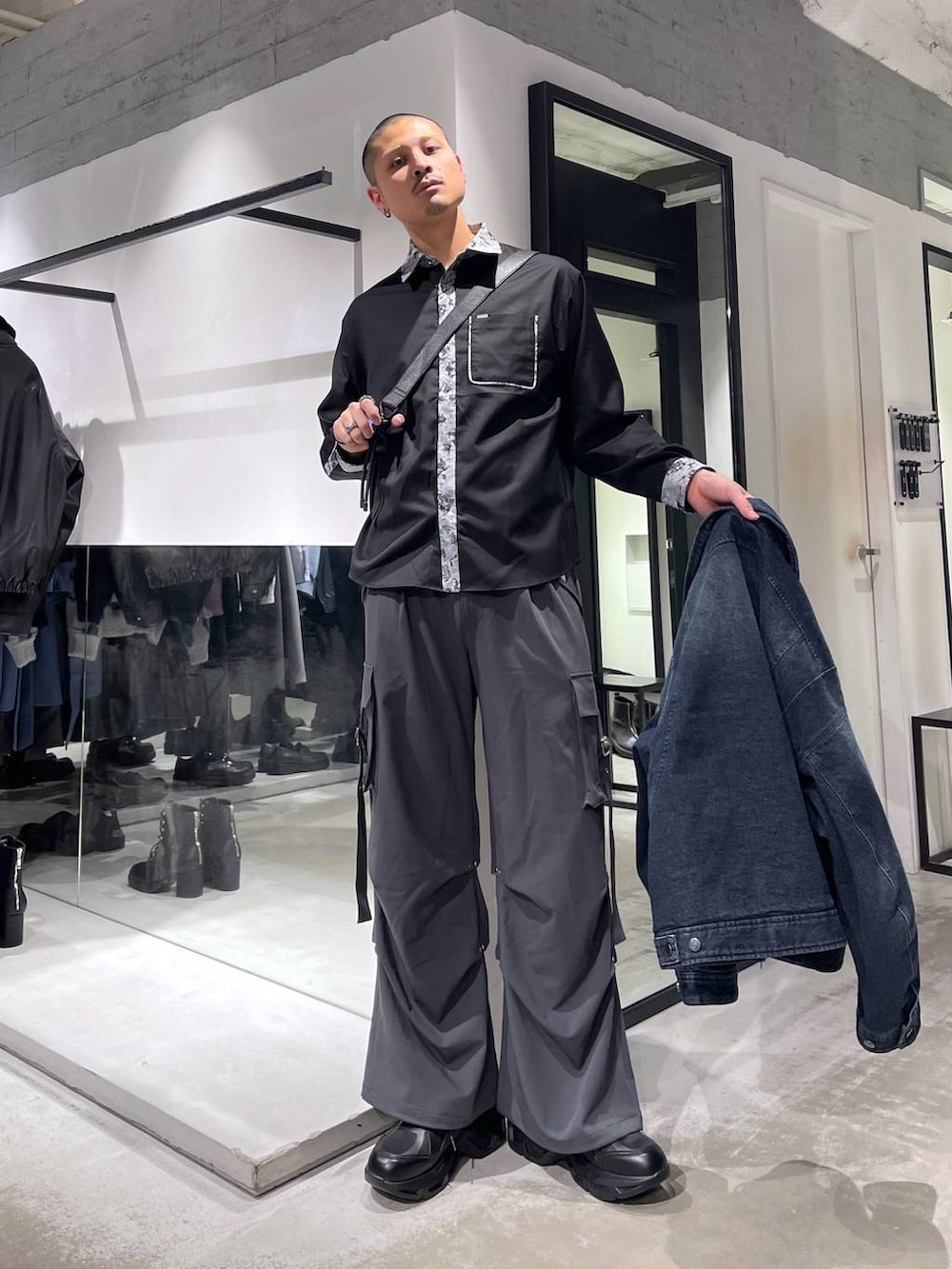 ブラック系のスニーカー、グレー系のカーゴパンツ、ブラック系のシャツ/ブラウスを着用したメンズの冬コーディネートの5枚目の写真