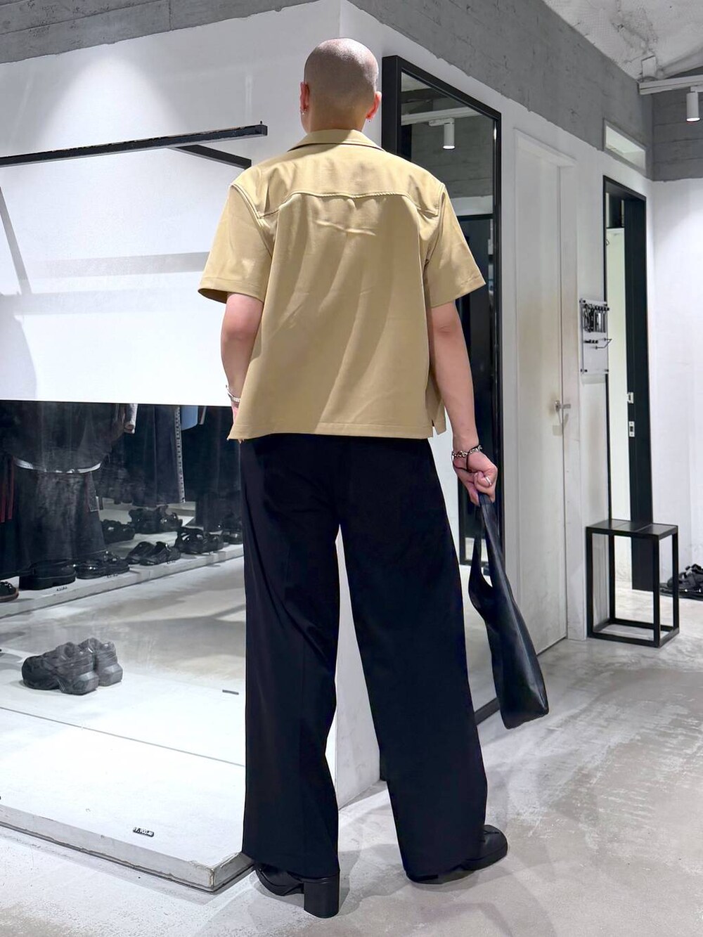 ホワイト系のTシャツ/カットソー、ブラック系のトートバッグ、ブラック系のサンダルを着用したメンズの夏コーディネートの3枚目の写真