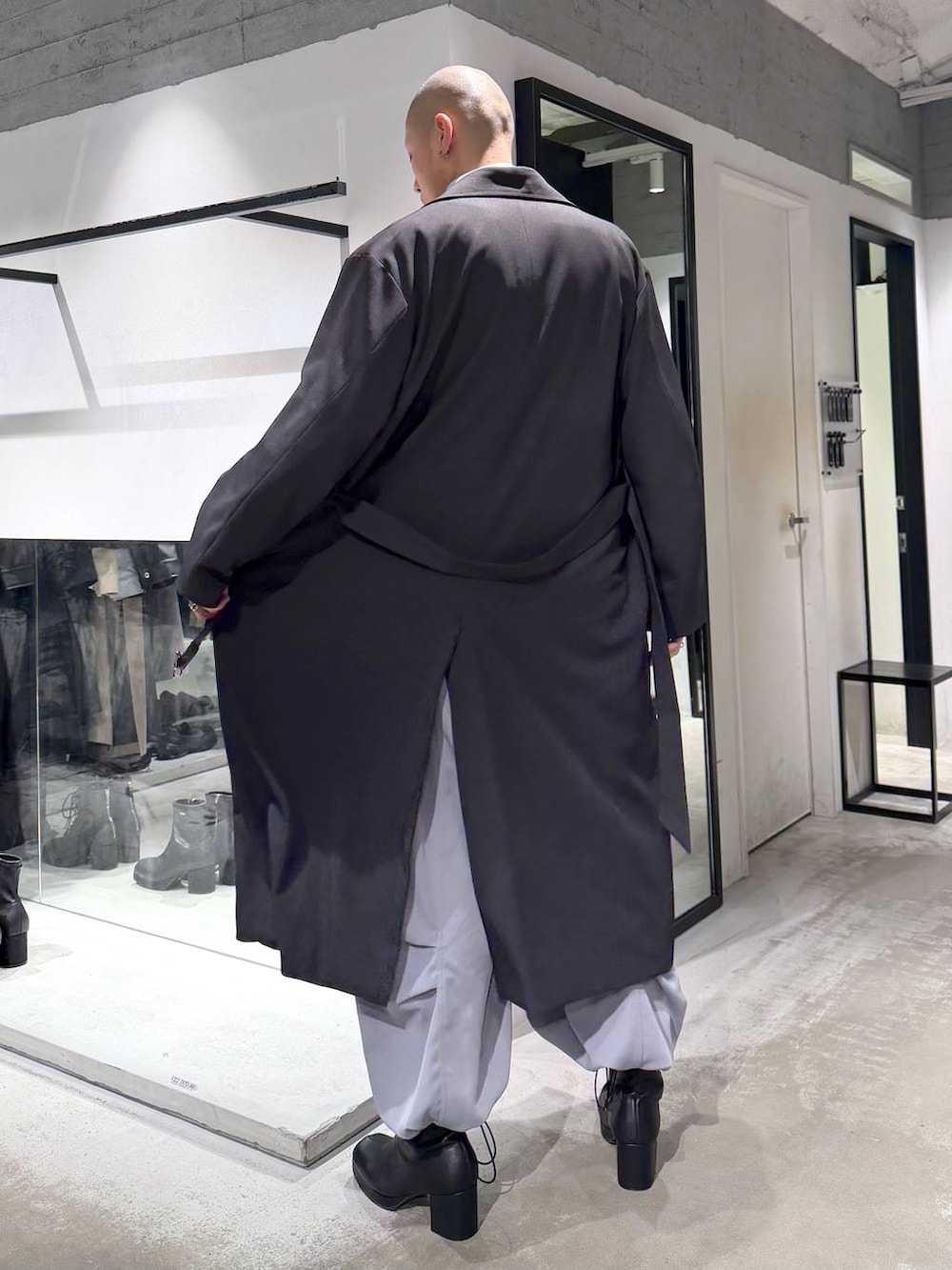 ブルー系のポロシャツ、ブラック系のブーツ、ブラック系のハンドバッグを着用したメンズの冬コーディネートの3枚目の写真