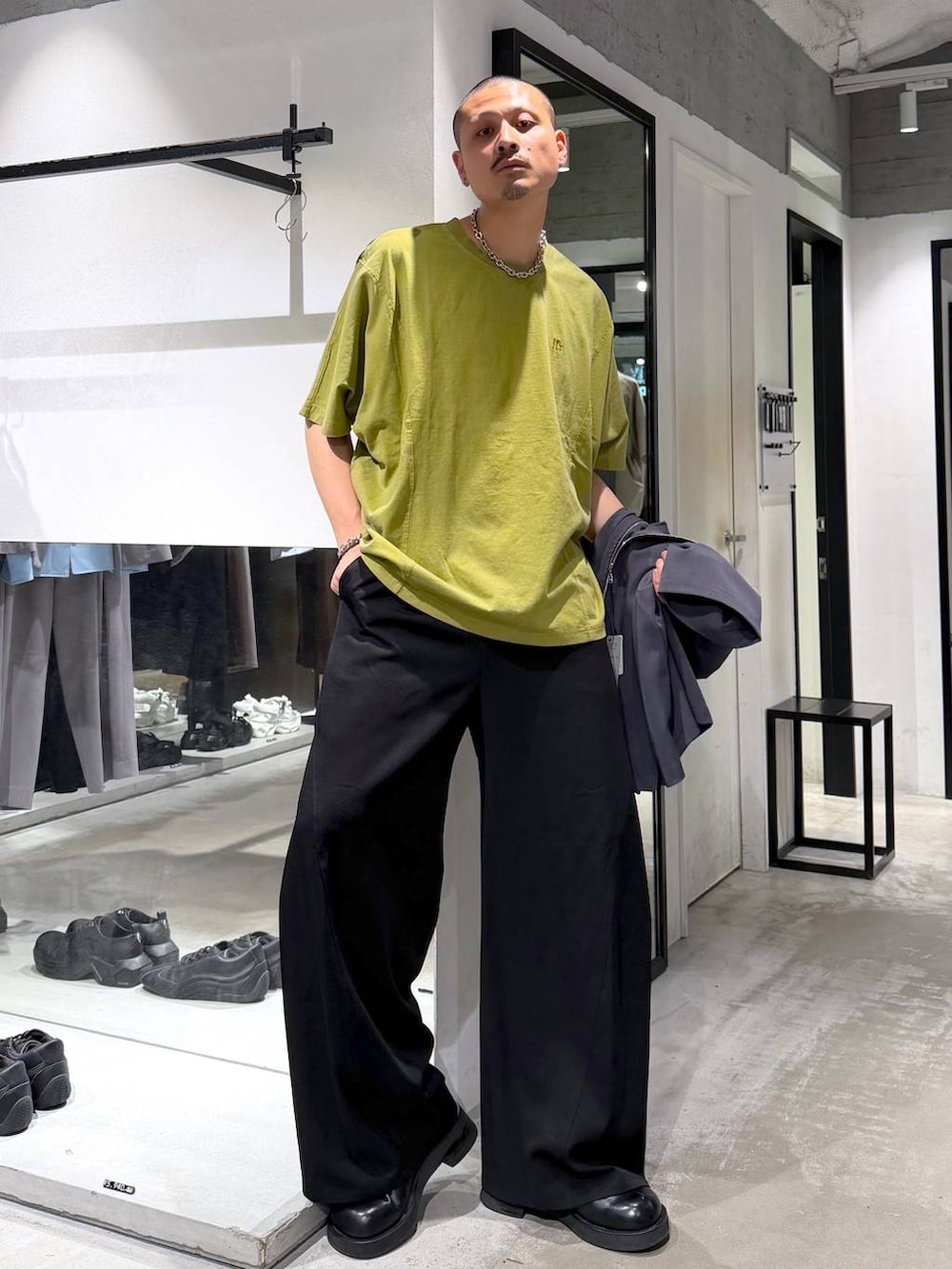 イエロー系のTシャツ/カットソー、ブラック系のトートバッグ、ブラック系のスラックスを着用したメンズの夏コーディネートの5枚目の写真