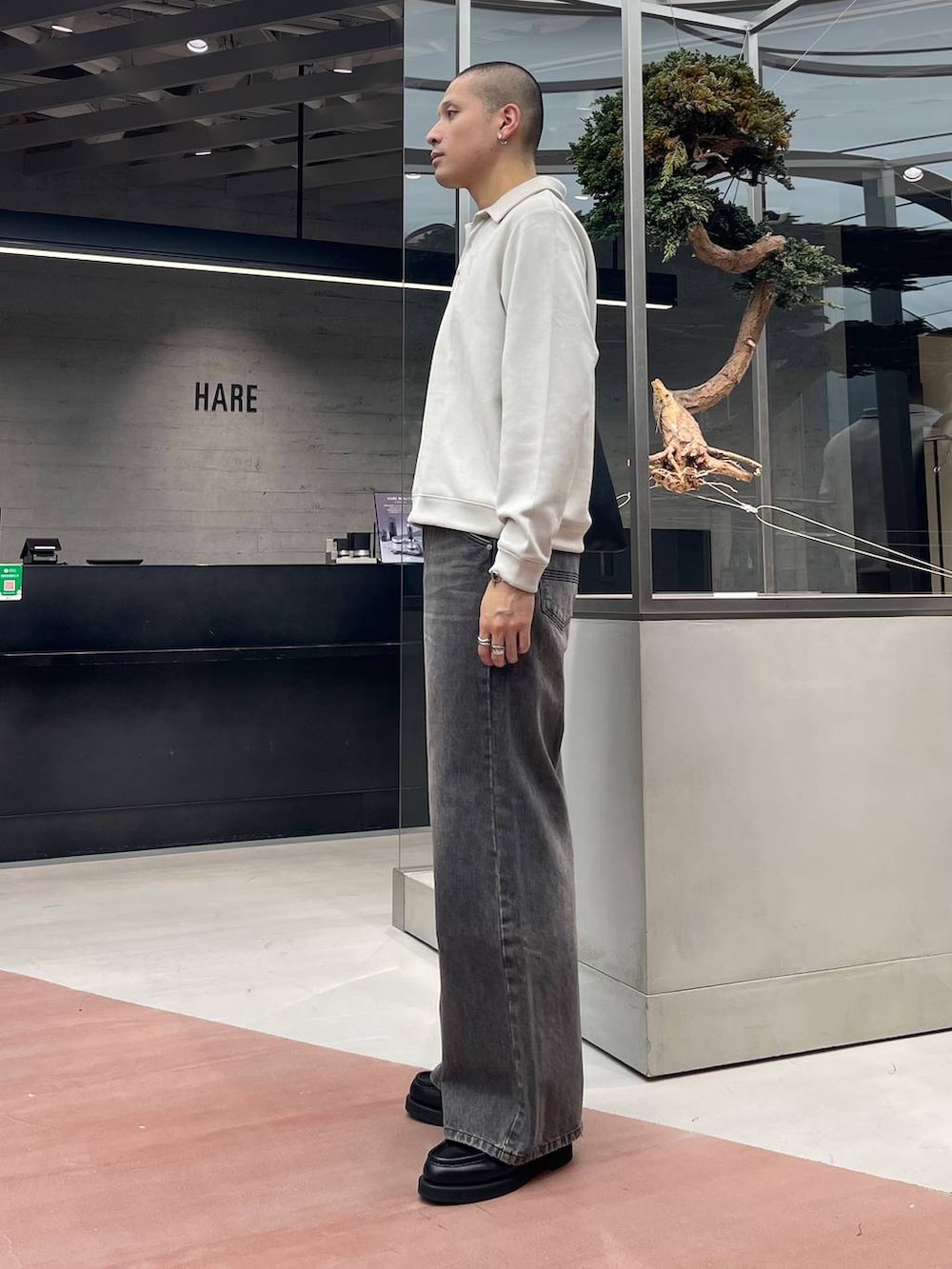 ブラック系のローファー、ブラウン系のデニムパンツ、ブラック系のトートバッグを着用したメンズの秋コーディネートの2枚目の写真