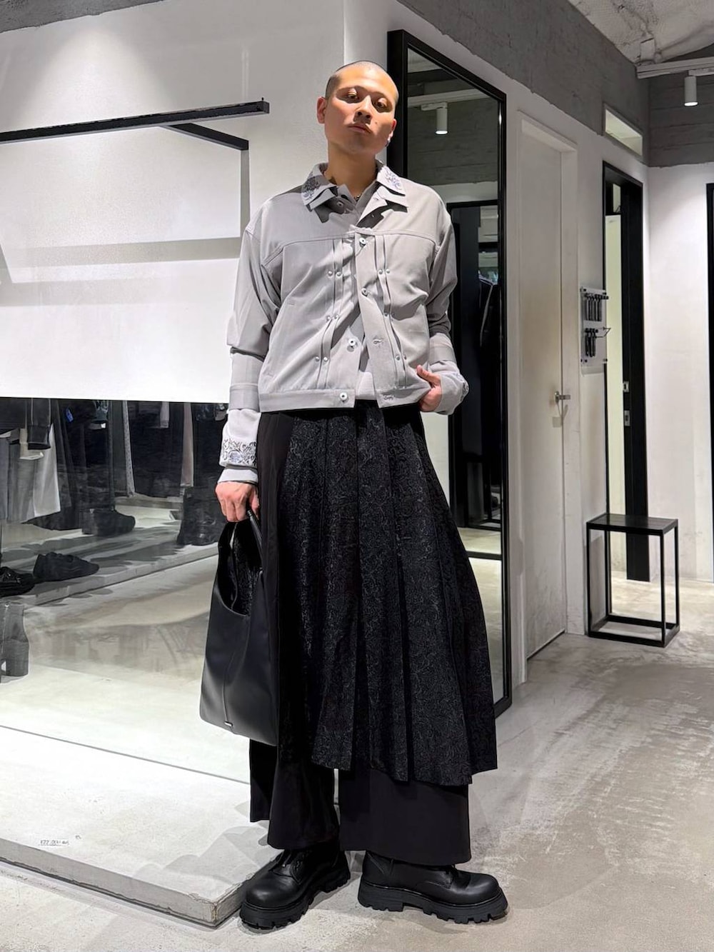 ブラック系のトートバッグ、グレー系のポロシャツ、ブラック系のその他パンツを着用したメンズの春コーディネートの2枚目の写真