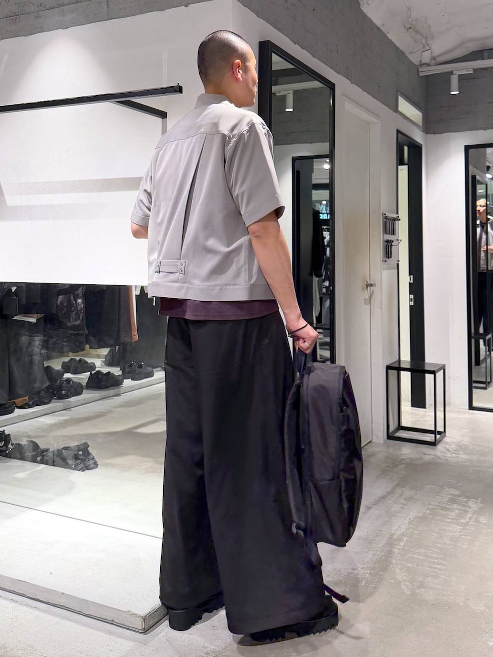 ブラック系のバックパック/リュック、ブラック系のサンダル、ブラック系のスラックスを着用したメンズの春コーディネートの4枚目の写真