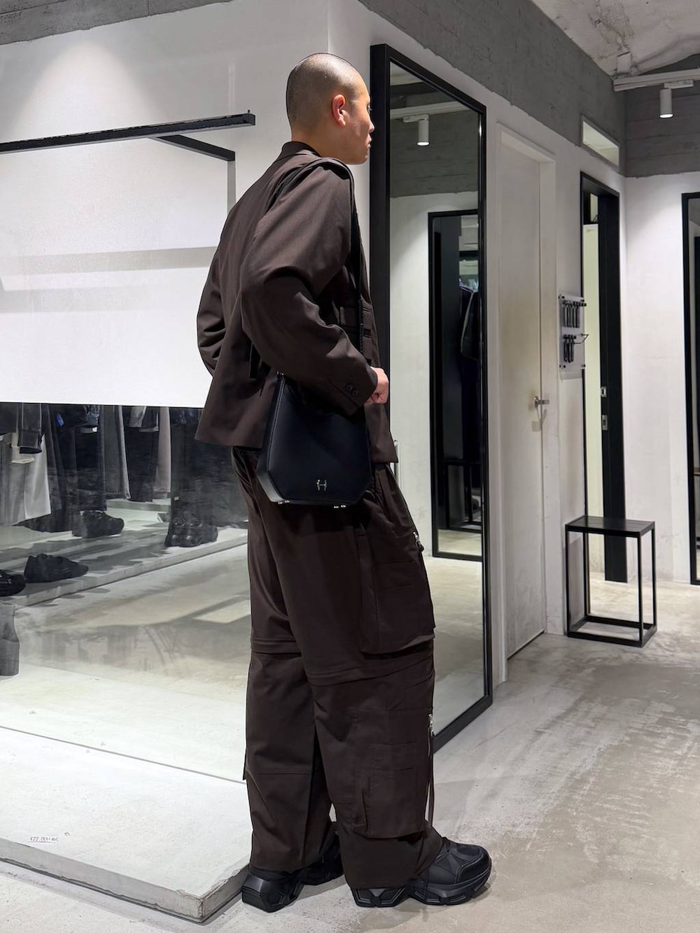 ブラック系のスニーカー、ブラウン系のテーラードジャケット、ブラウン系のカーゴパンツを着用したメンズの春コーディネートの4枚目の写真