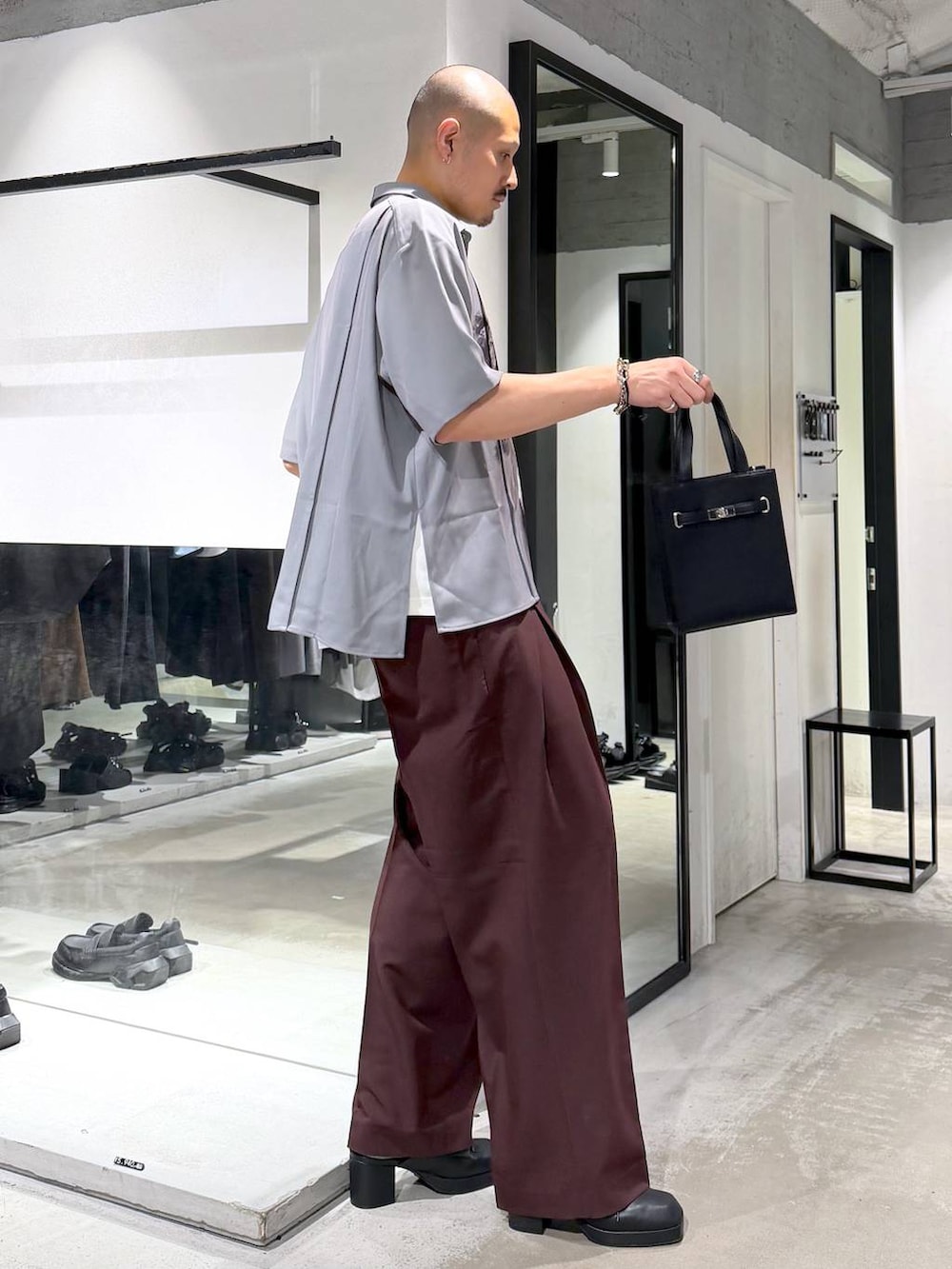グレー系のシャツ/ブラウス、ブラック系のサンダル、レッド系のスラックスを着用したメンズの夏コーディネートの4枚目の写真