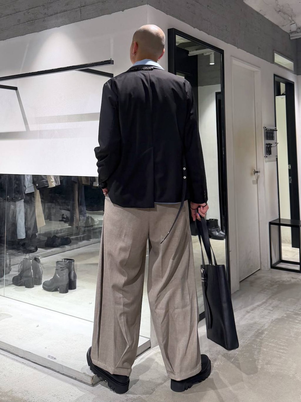 ブラック系のドレスシューズ、ブラック系のトートバッグ、ブラック系のテーラードジャケットを着用したメンズの冬コーディネートの3枚目の写真