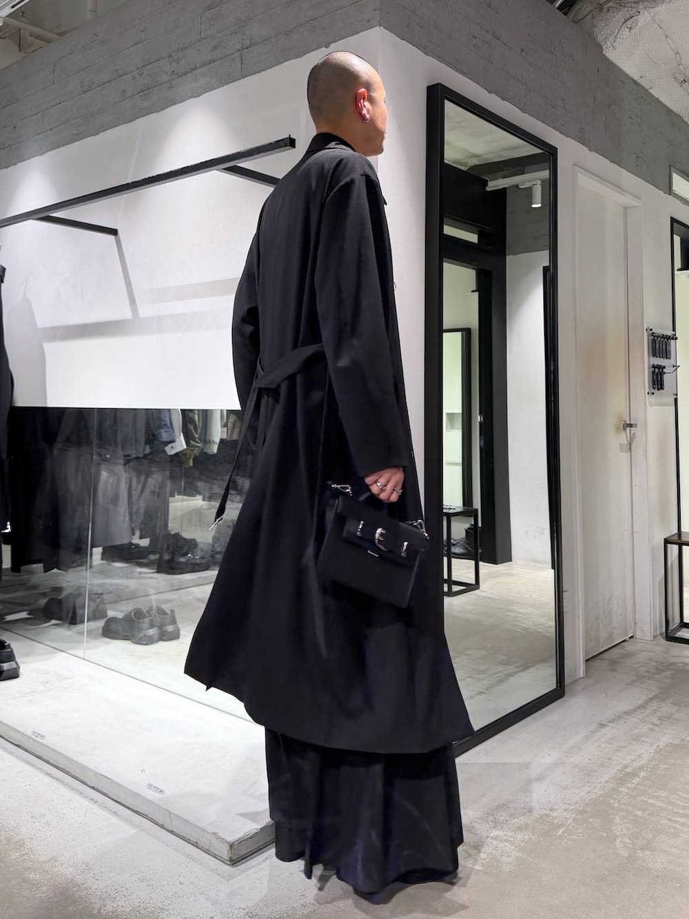 グレー系のその他パンツ、ブラック系のブーツ、ブラック系のハンドバッグを着用したメンズの冬コーディネートの4枚目の写真