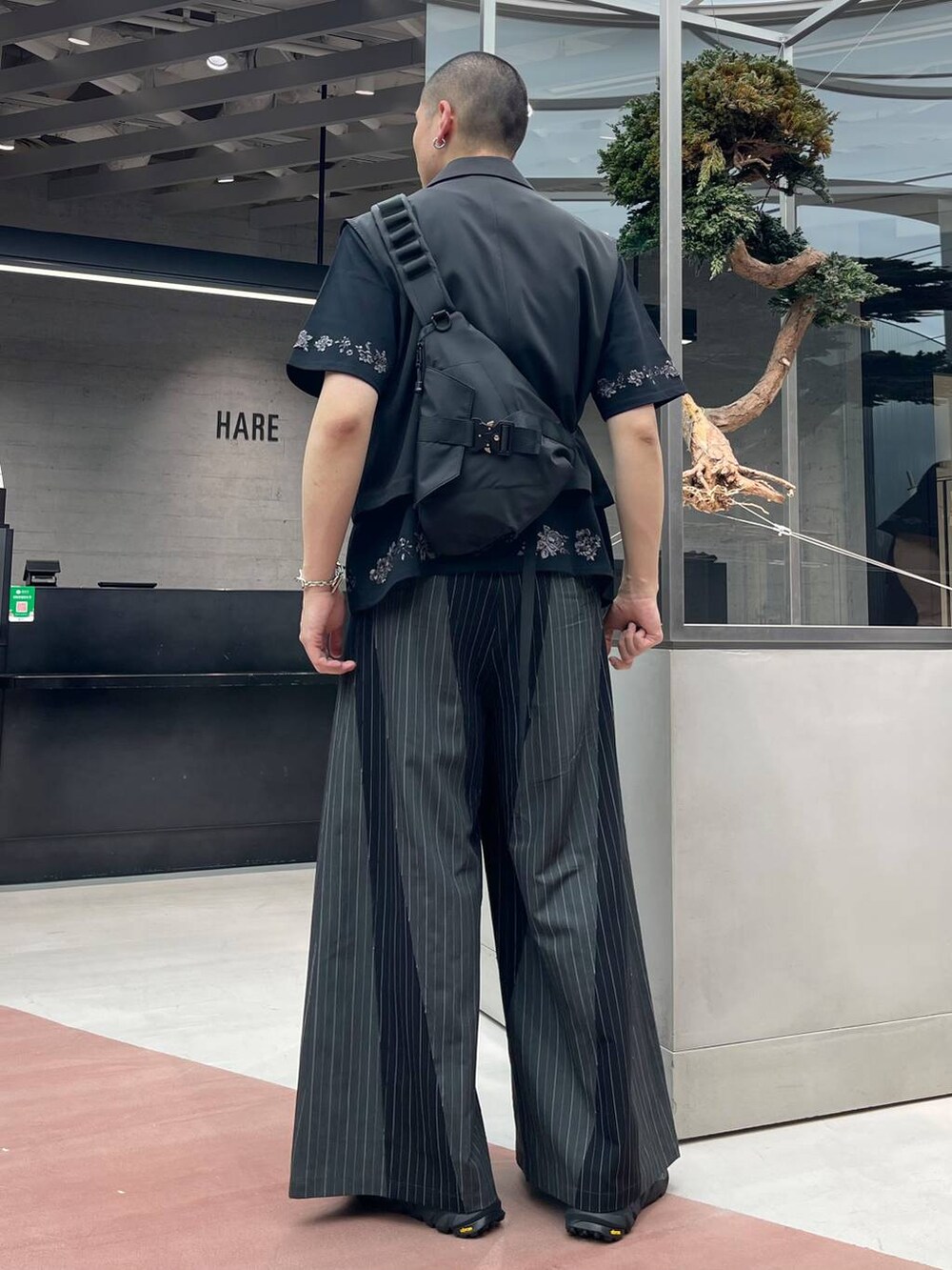 ブラック系のサンダル、ブラック系のベスト、ブラック系のTシャツ/カットソーを着用したメンズの春コーディネートの2枚目の写真