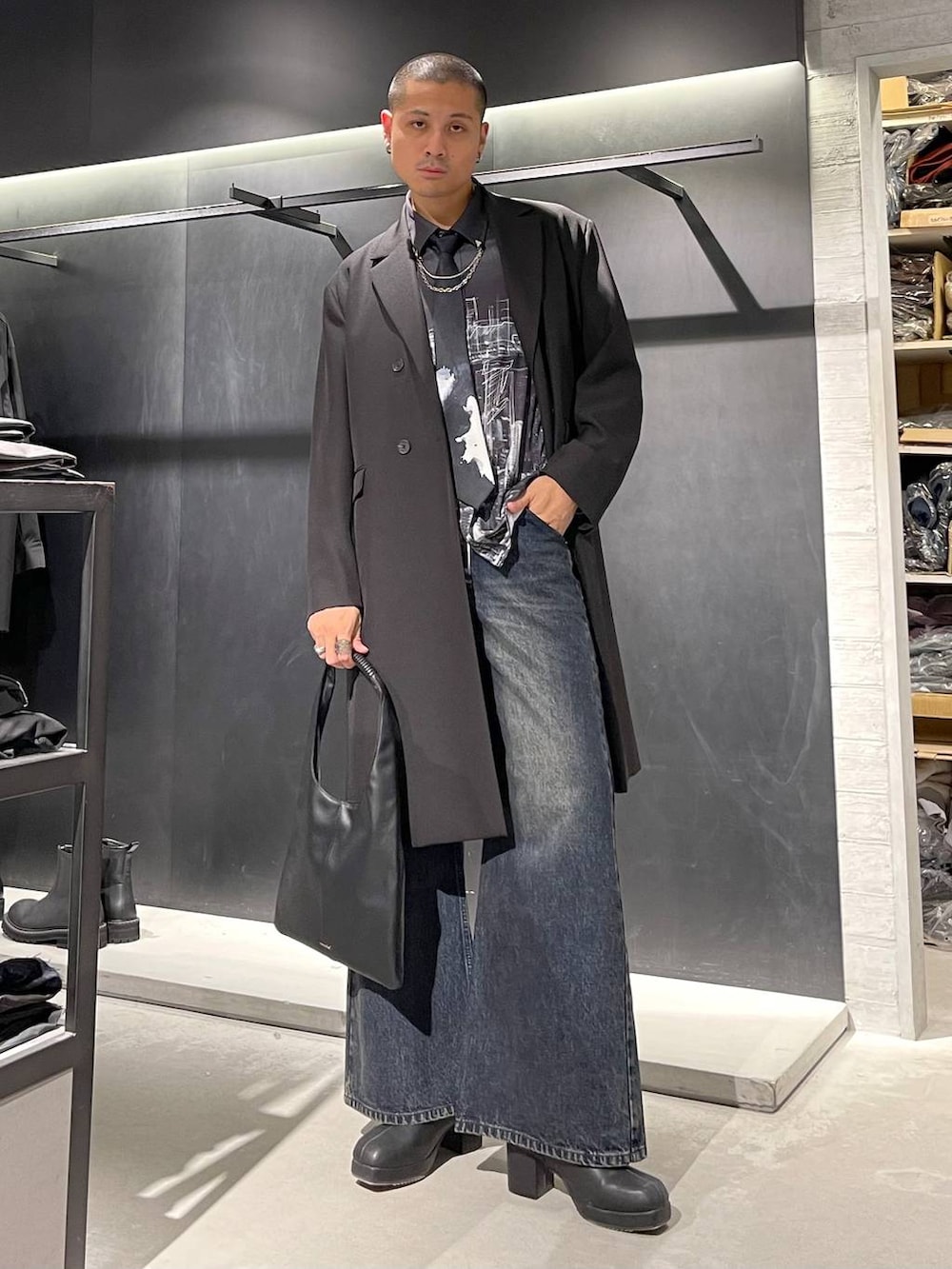 ブラック系のトートバッグ、ブラック系のネクタイ、ブルー系のデニムパンツを着用したメンズの秋コーディネートの2枚目の写真