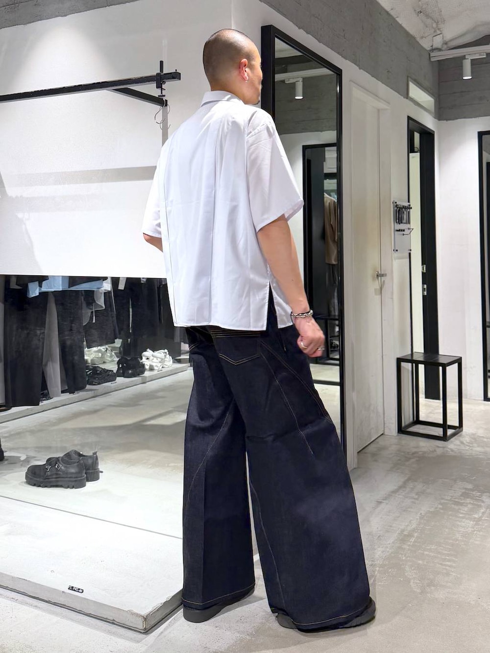 ブルー系のデニムパンツ、ブラック系のサンダル、ホワイト系のシャツ/ブラウスを着用したメンズの夏コーディネートの4枚目の写真
