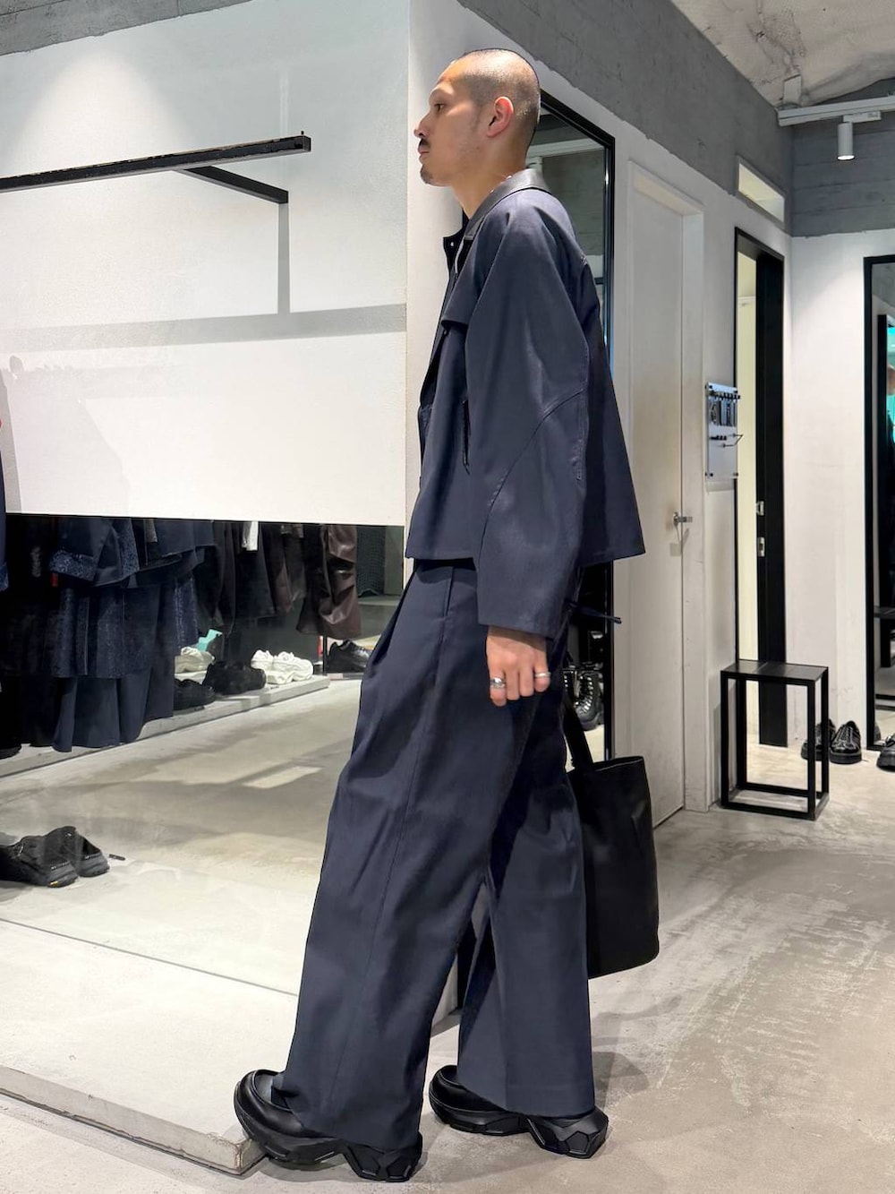 ブラック系のポロシャツ、ブルー系のスラックス、ブルー系のブルゾンを着用したメンズの秋コーディネートの2枚目の写真
