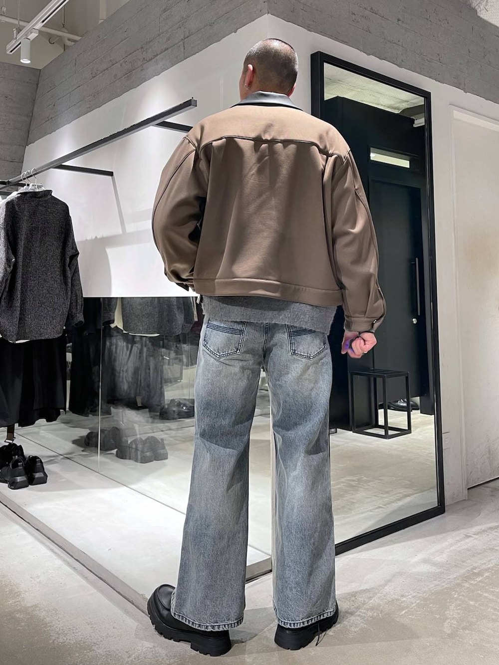 ブルー系のネクタイ、ブラック系のカーディガン/ボレロ、ブルー系のデニムパンツを着用したメンズの冬コーディネートの3枚目の写真