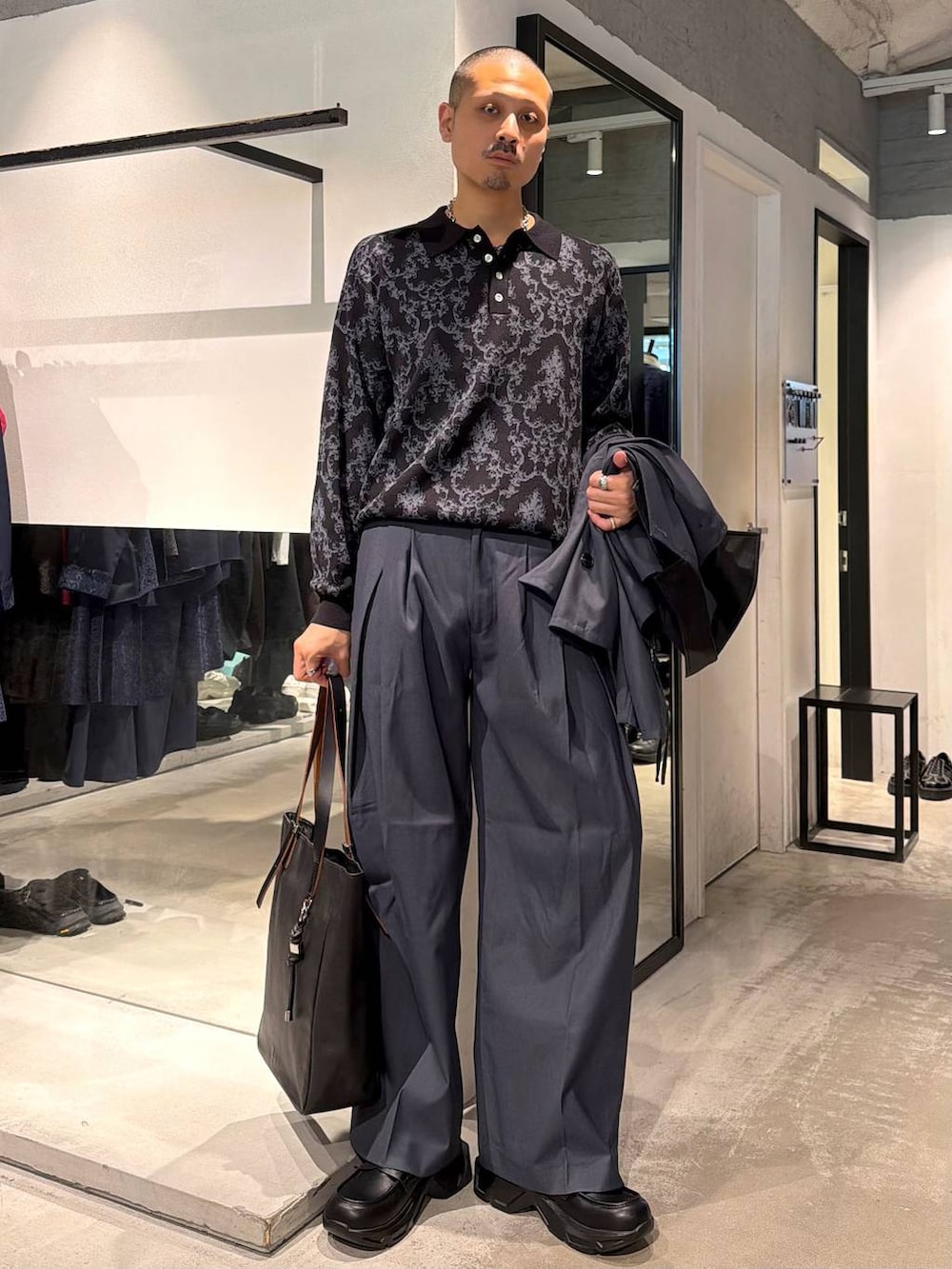 ブラック系のポロシャツ、ブルー系のスラックス、ブルー系のブルゾンを着用したメンズの秋コーディネートの6枚目の写真