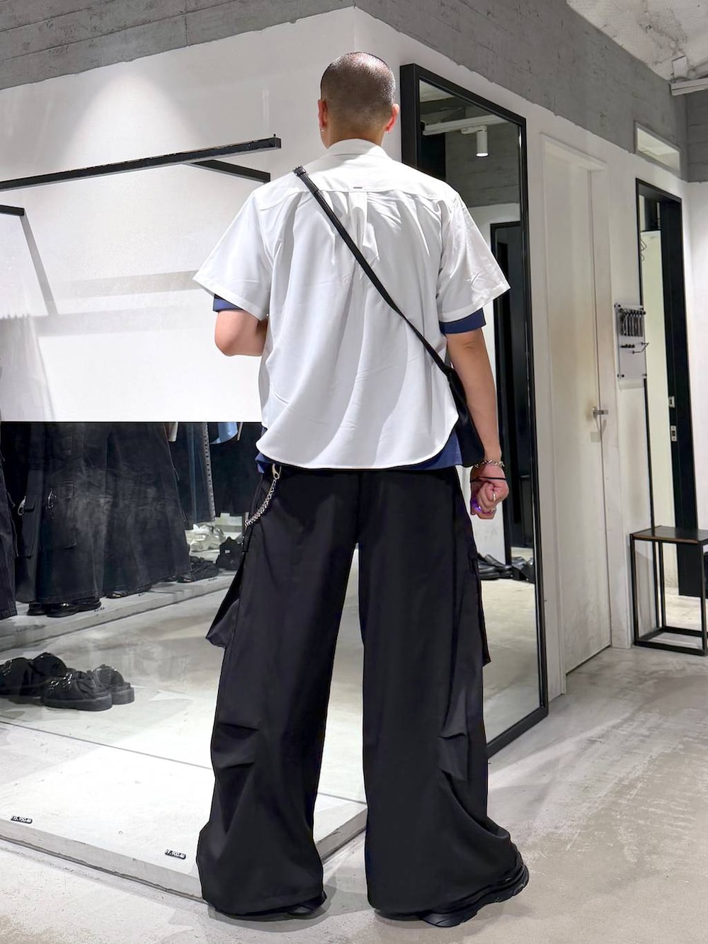 ブラック系のショルダーバッグ、ホワイト系のシャツ/ブラウス、ブラック系のカーゴパンツを着用したメンズの夏コーディネートの3枚目の写真