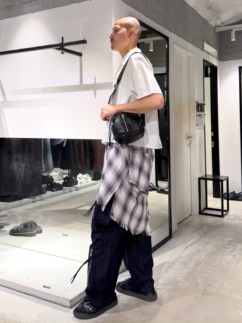 ブラック系のショルダーバッグ、ブラック系のサンダル、ブルー系のカーゴパンツを着用したメンズの夏コーディネートの2枚目の写真